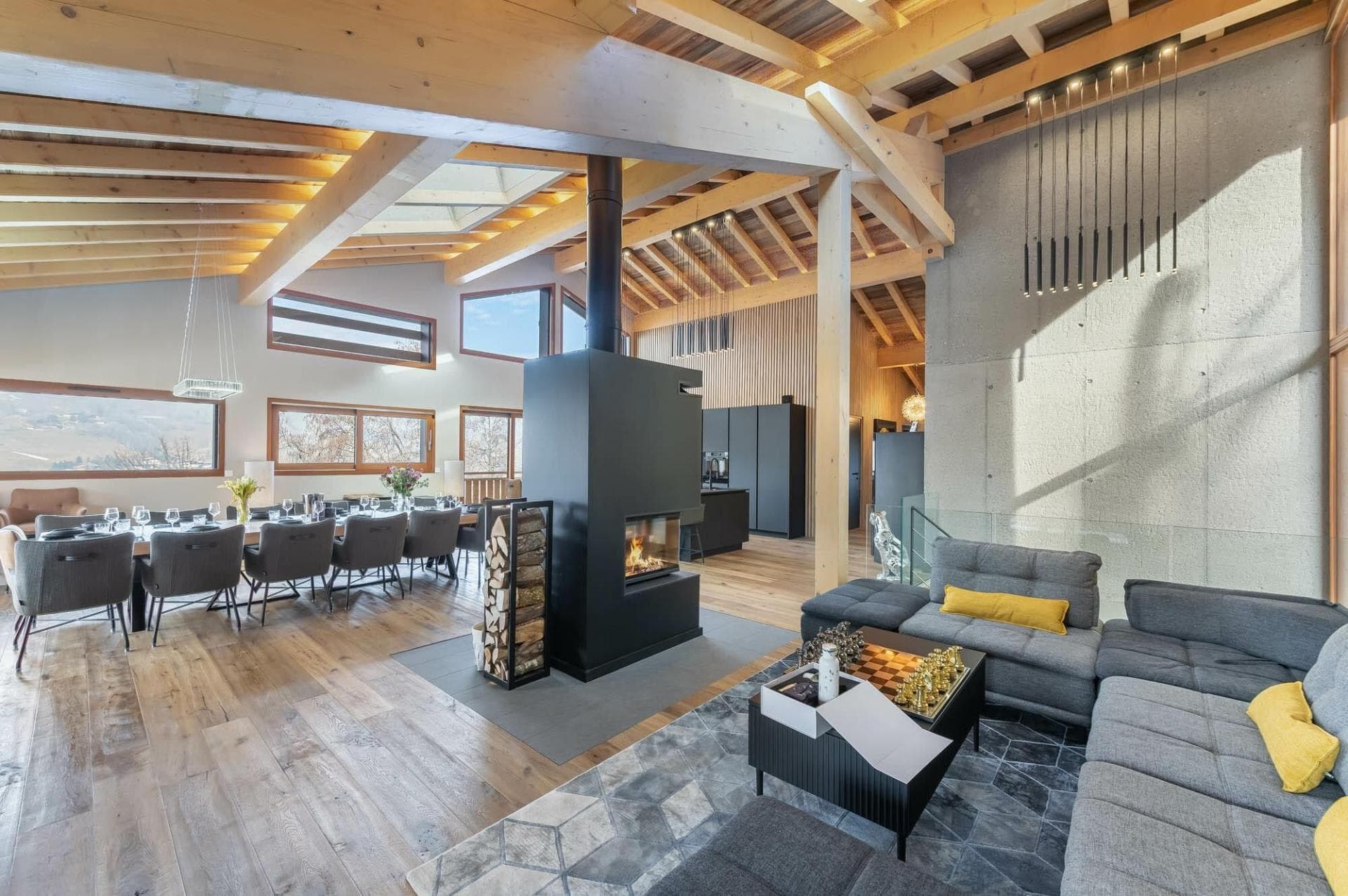 Open-plan living area with central wood-burning fireplace and dining for 10