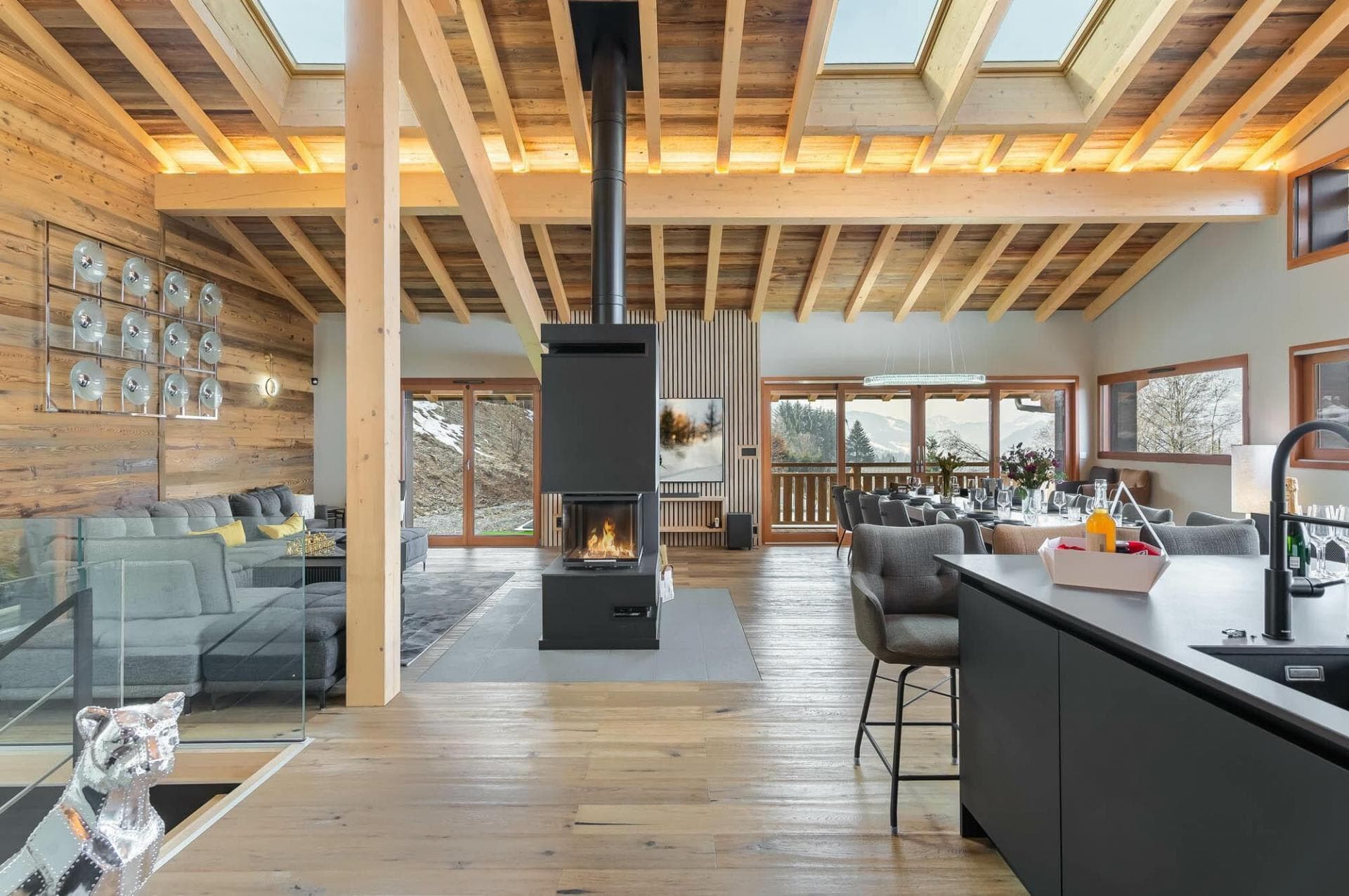 Open-plan living area with central wood-burning fireplace and skylights