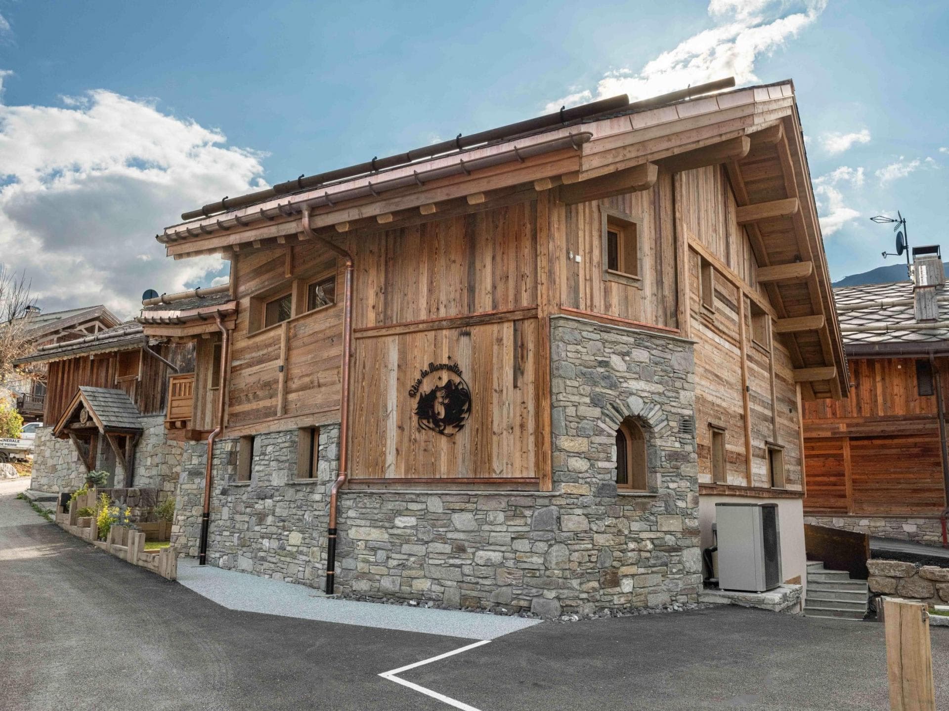 Chalet exterior with stone masonry and private driveway parking