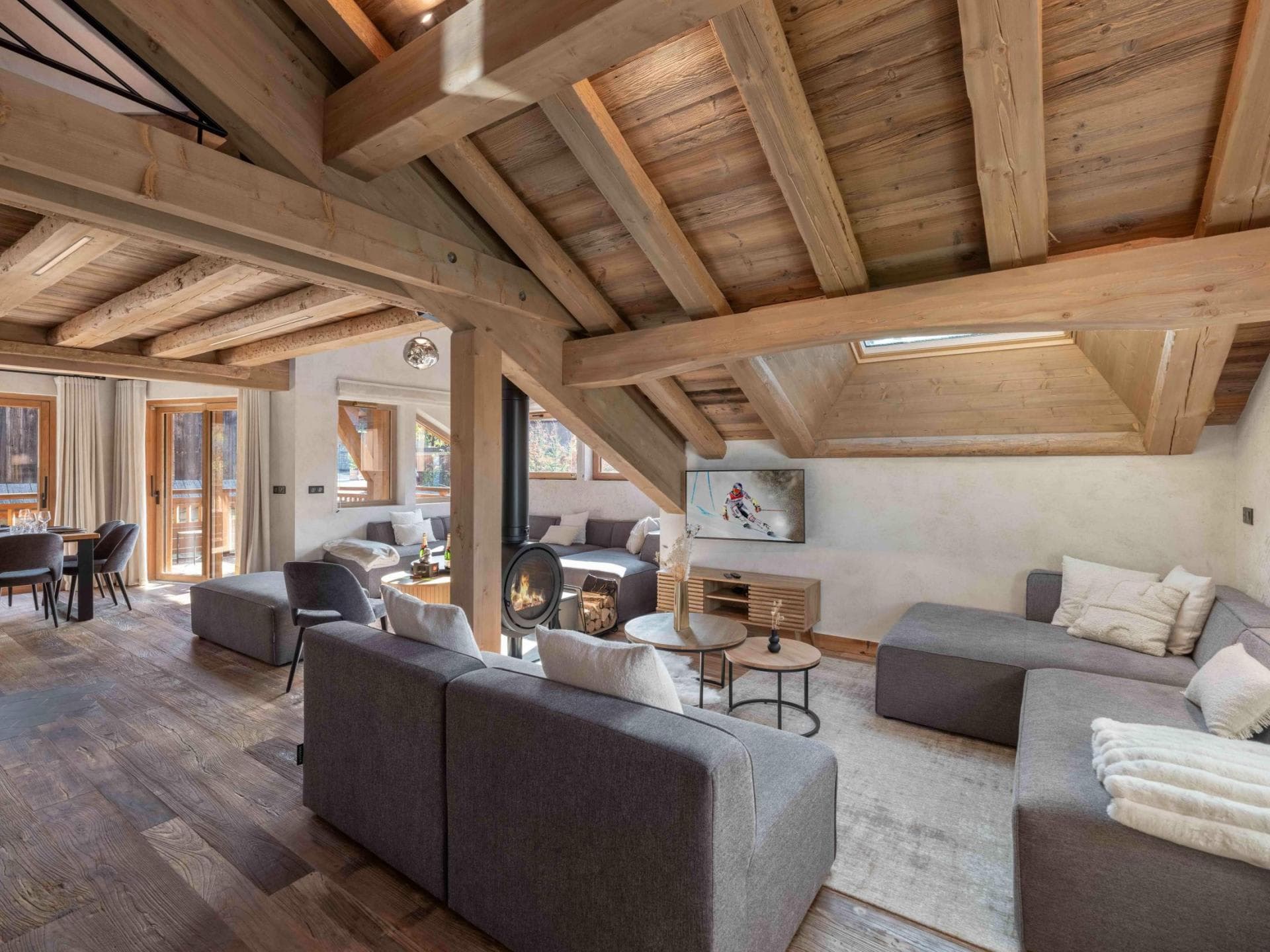 Open living area with wood-burning stove and vaulted timber ceilings