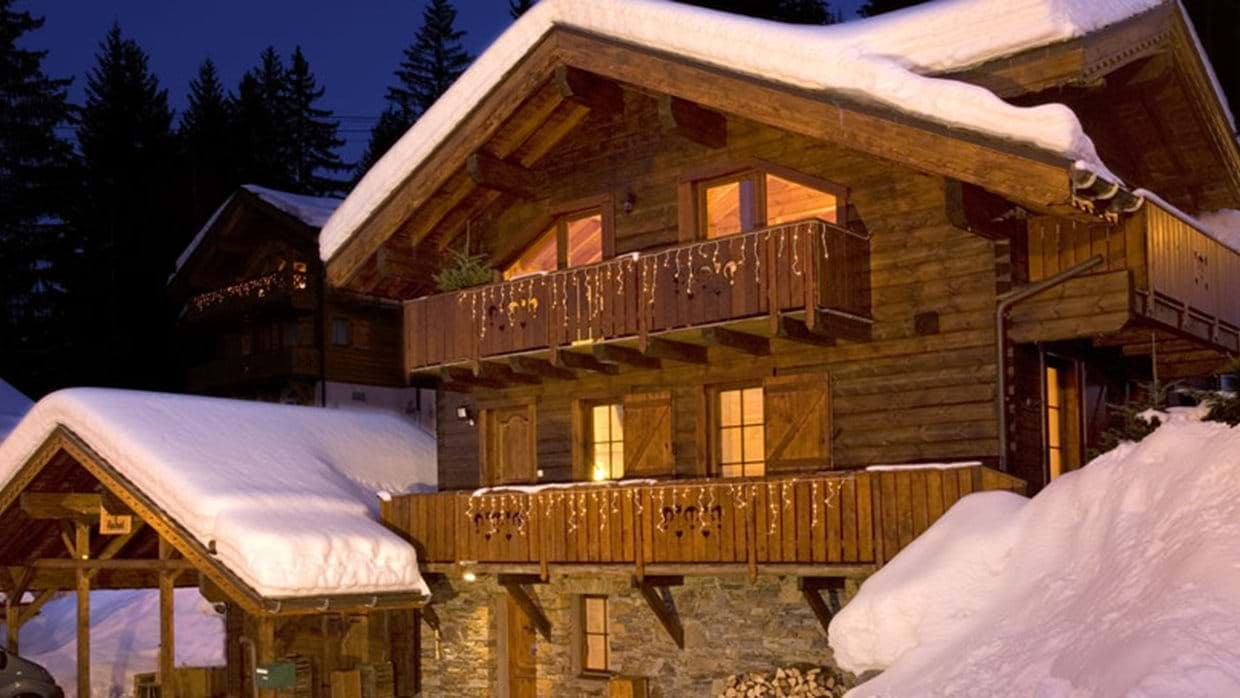 Three-story mountain chalet with dual balconies and covered carport