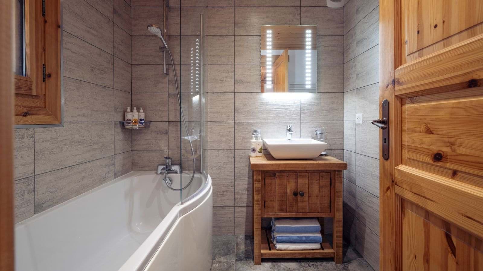 Bathroom with shower-tub combo and backlit LED vanity mirror