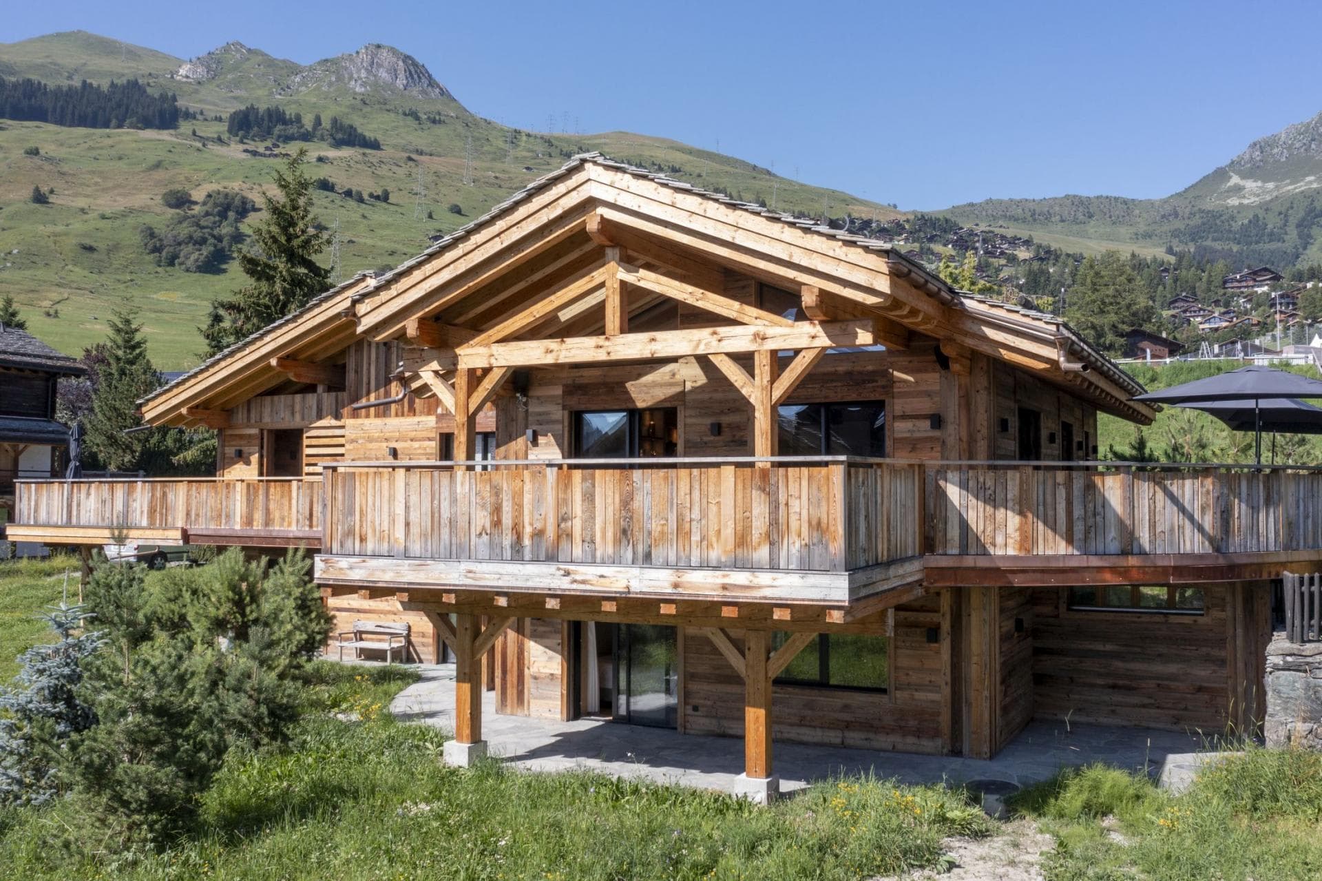 Timber chalet exterior with wraparound balcony and mountain views