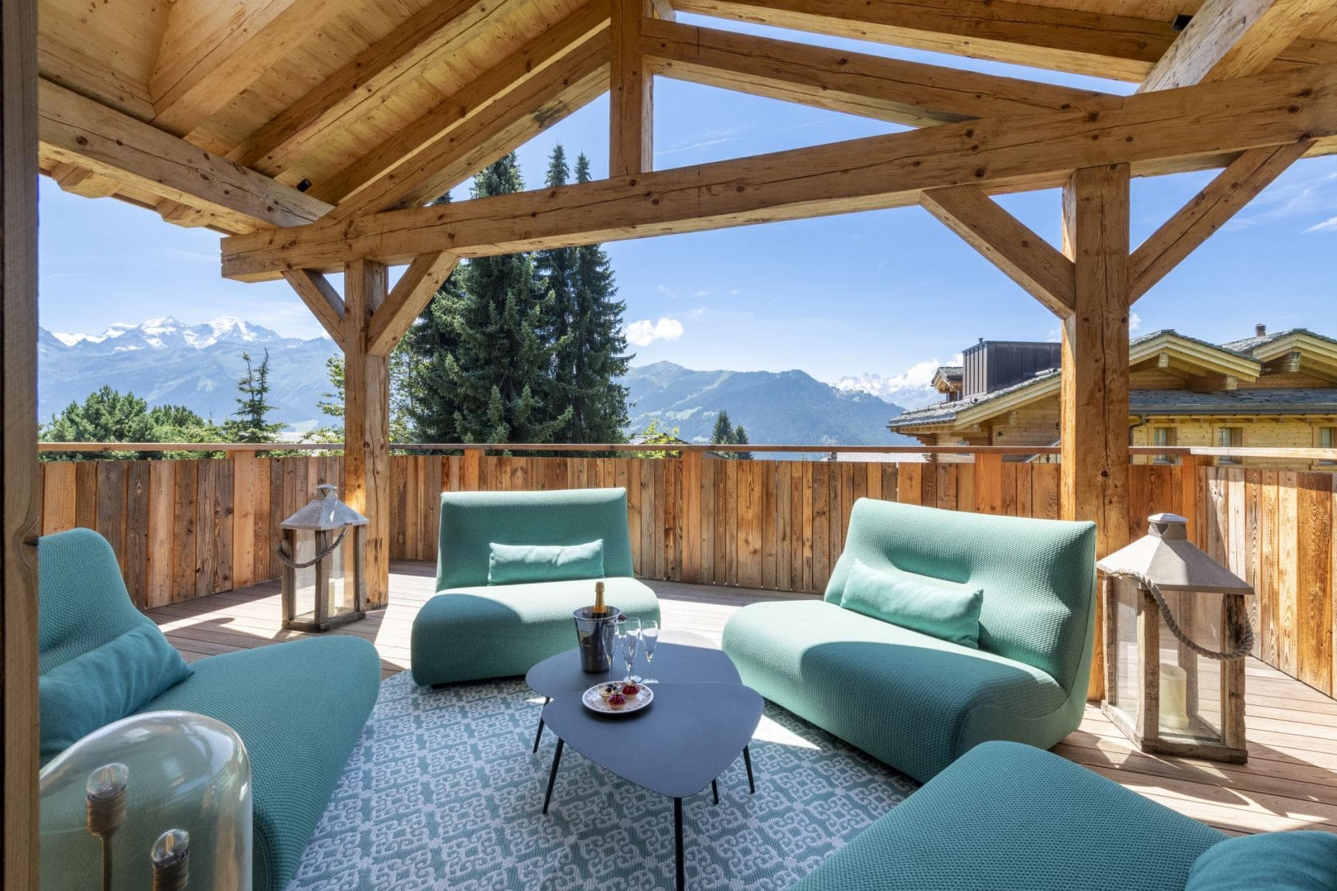 Covered timber balcony with lounge seating and panoramic alpine views