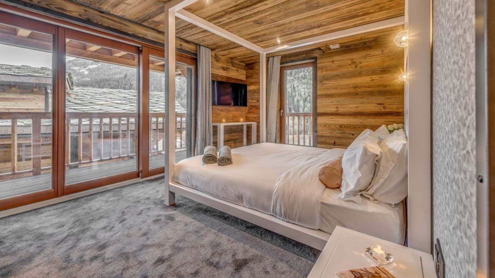 Primary bedroom with four-poster king bed and private balcony access