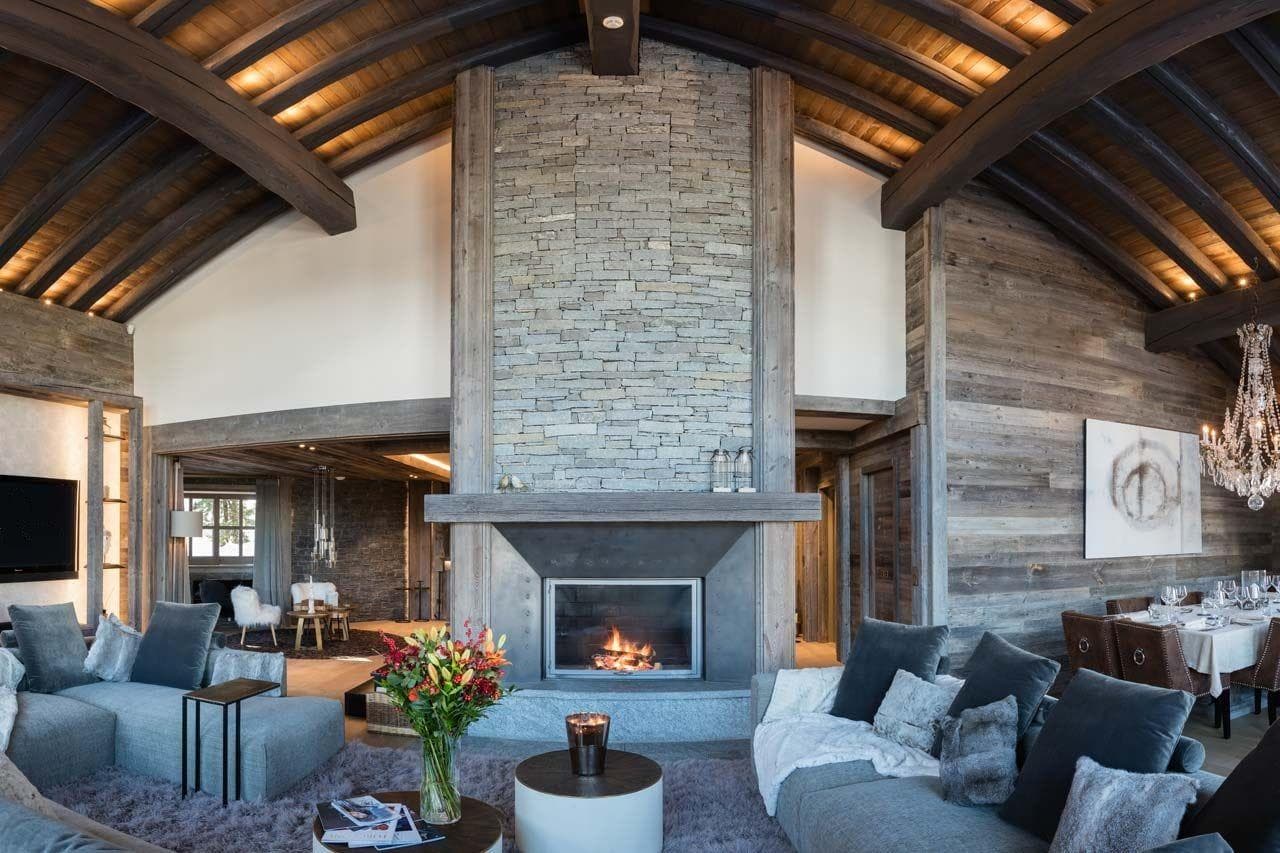 Open living area with floor-to-ceiling stone fireplace and vaulted timber ceilings