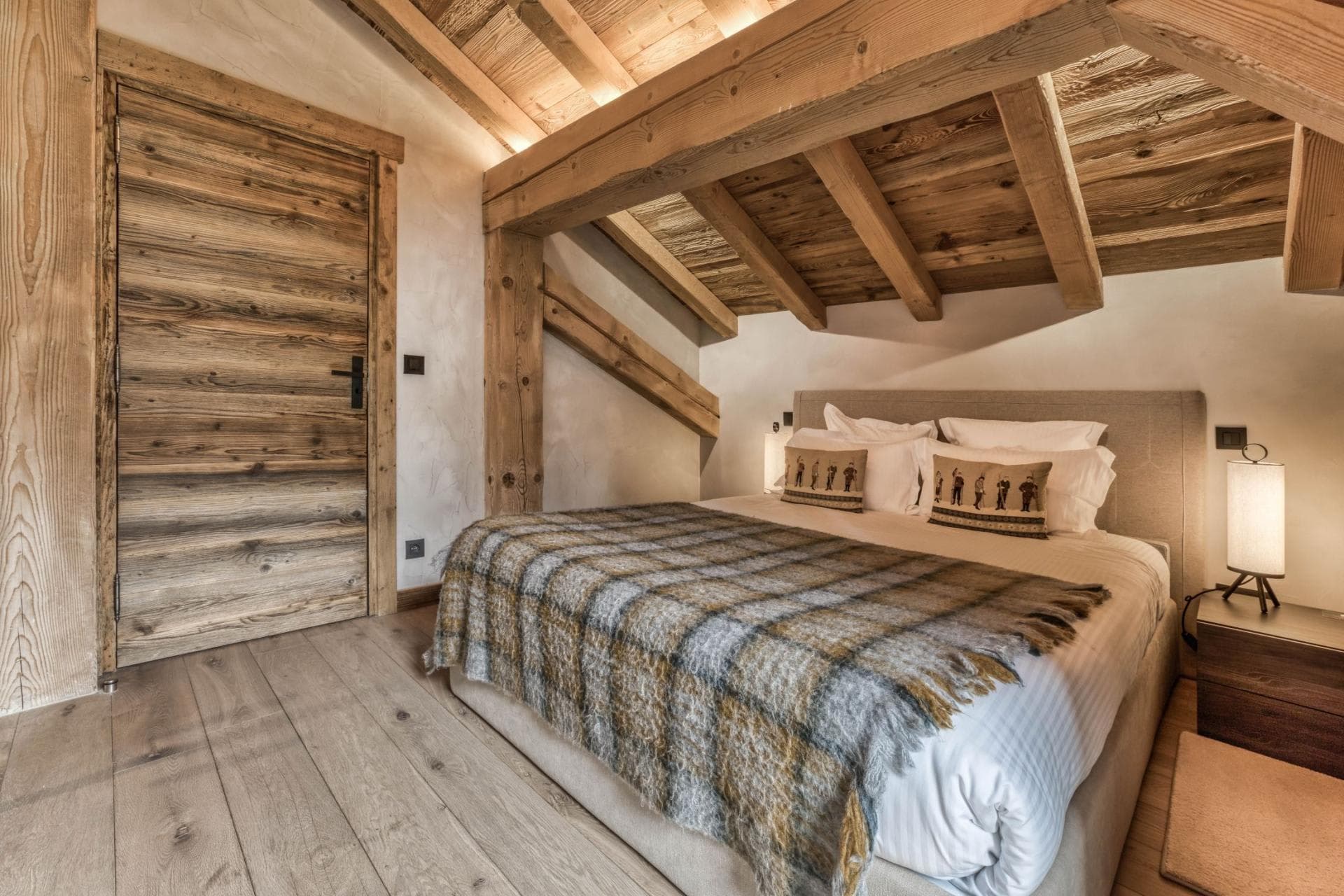 Bedroom with king bed and sloped wood-beam ceiling