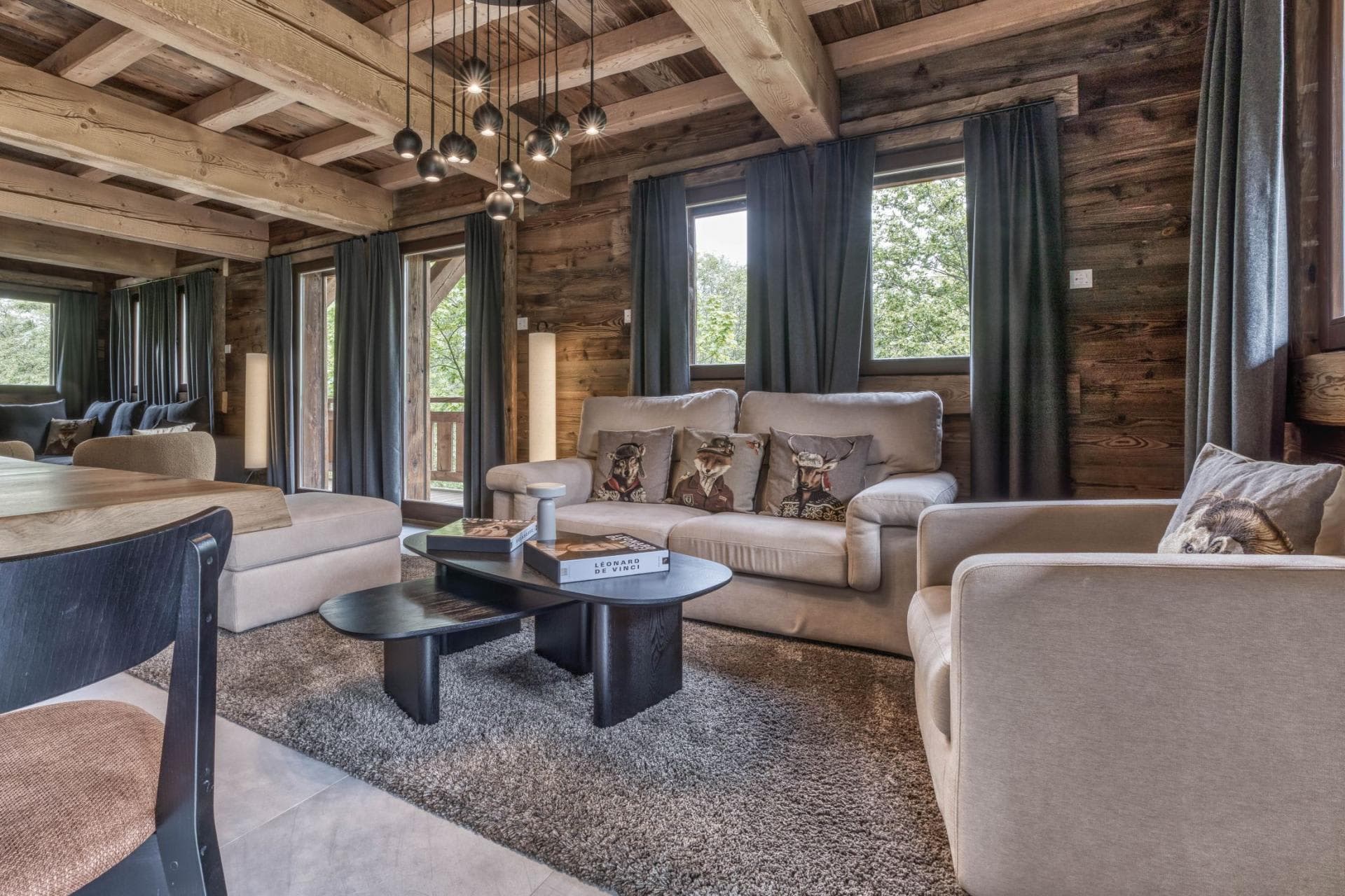 Living area with timber beams and forest-facing balcony access
