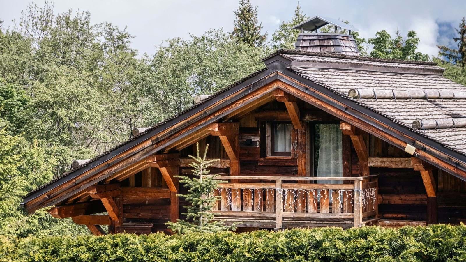 Timber chalet exterior with private balcony and traditional shingle roof