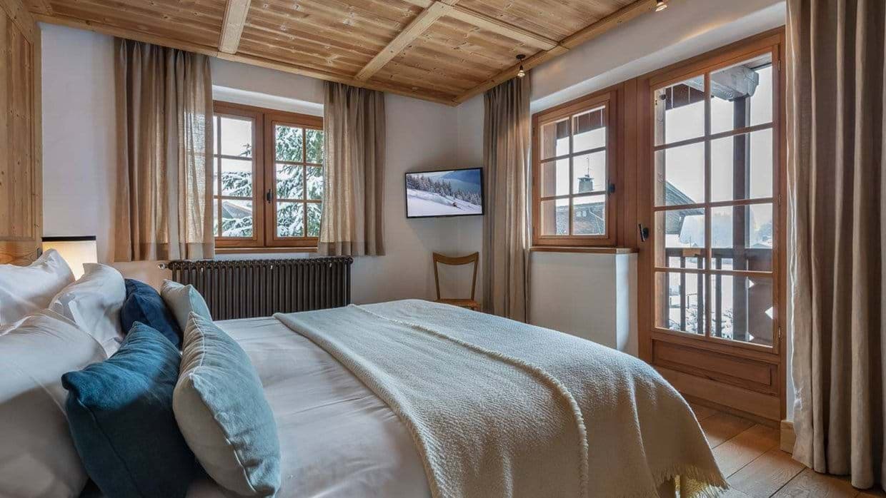 Guest bedroom with timber-clad ceiling and direct balcony access