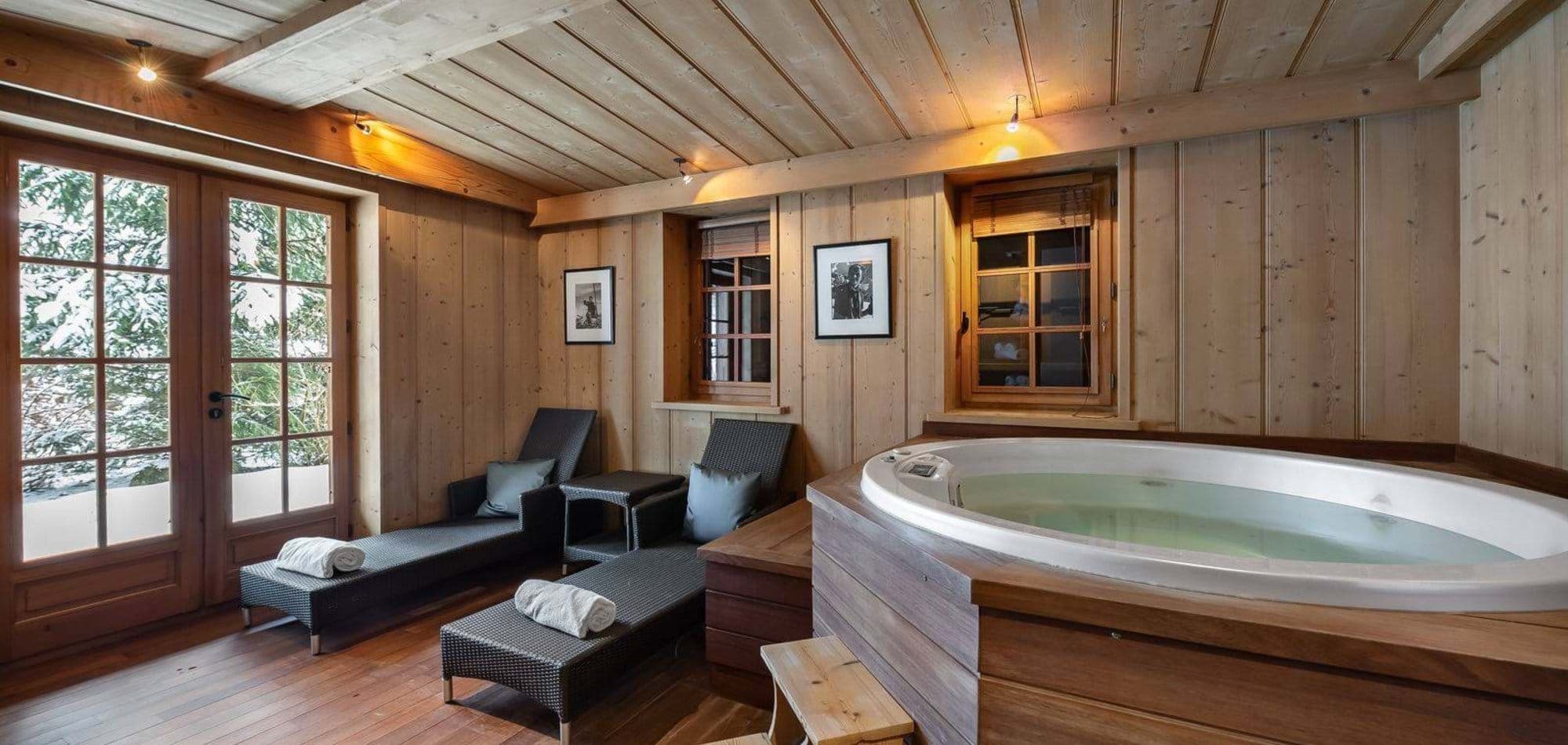 Indoor wellness room with whirlpool tub and dual loungers