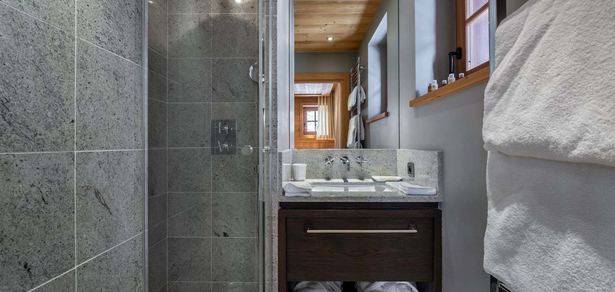 Bathroom featuring granite walk-in shower and heated towel rack