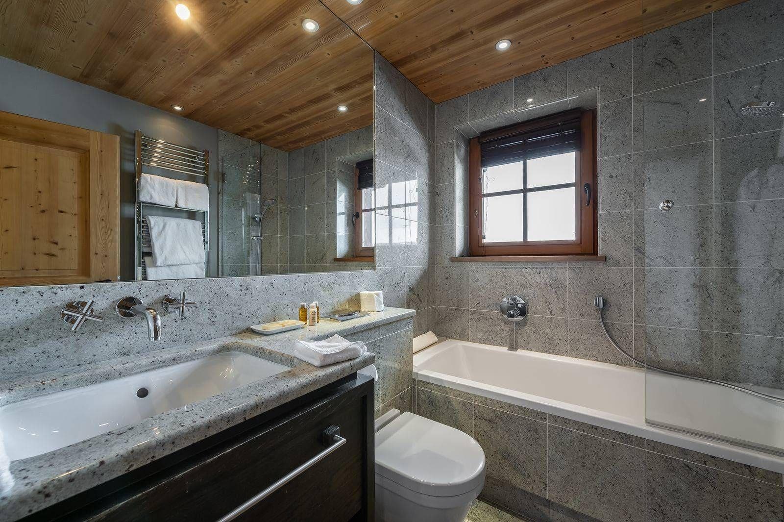 Bathroom with soaking tub, heated towel rack, and walk-in rainfall shower