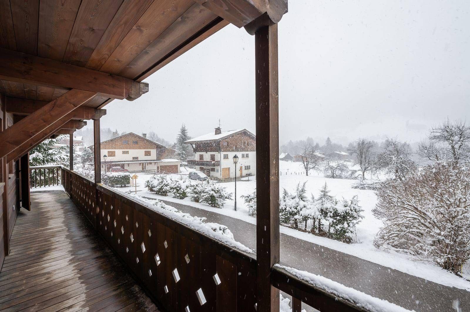 Covered timber balcony with village and mountain views