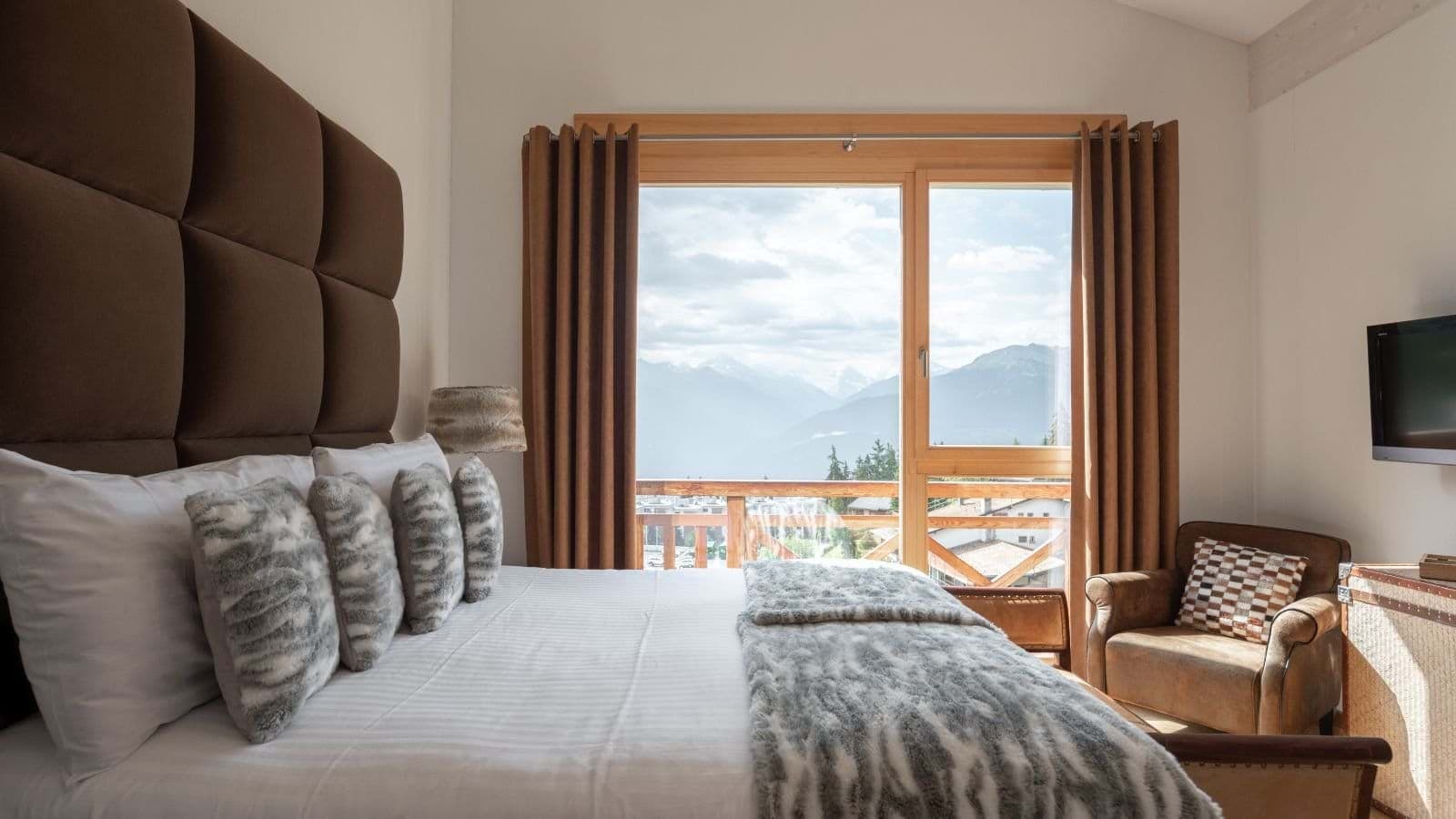Bedroom with mountain views, king bed, and balcony access