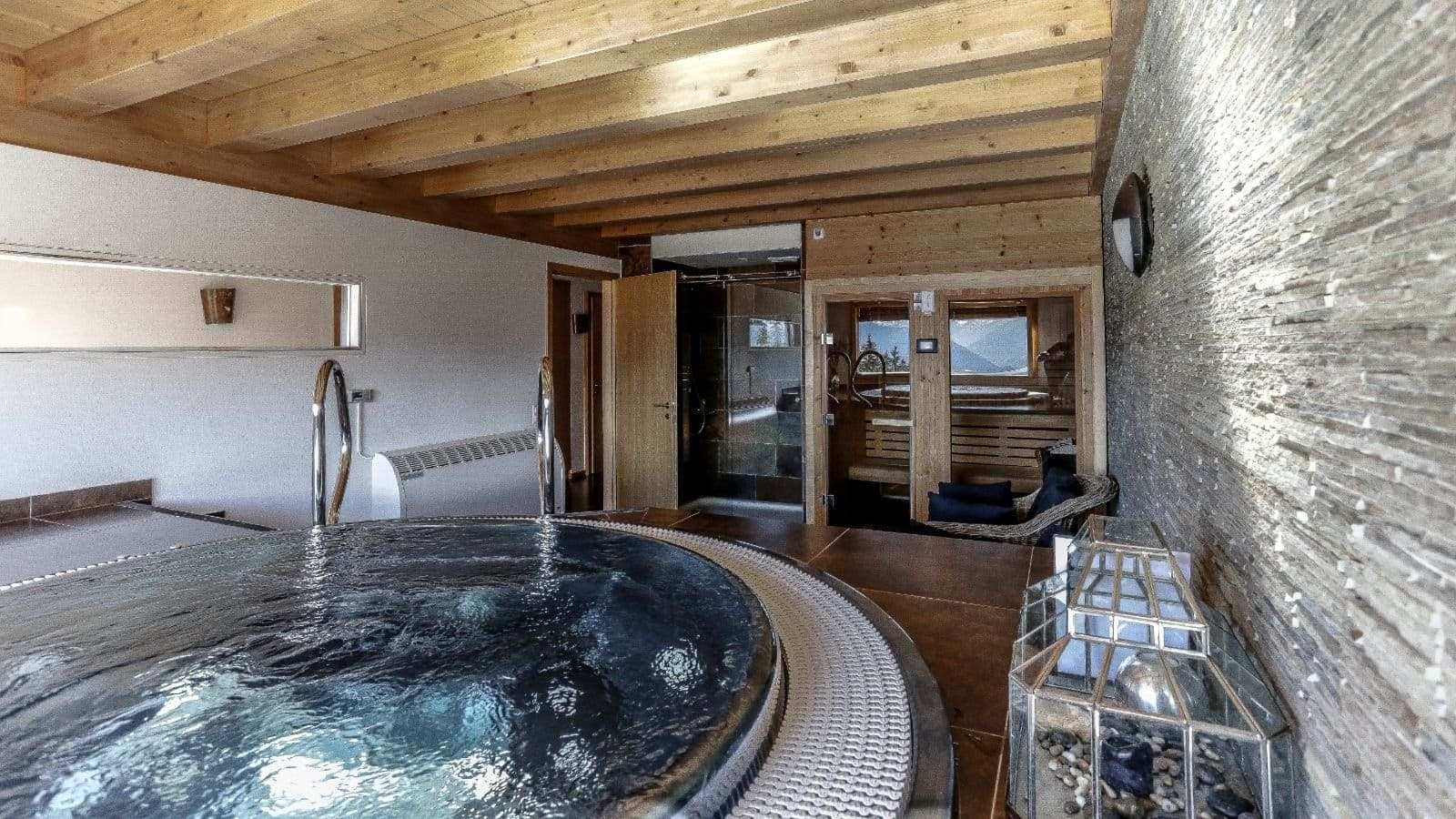 Indoor wellness area with hot tub, sauna, and walk-in rain shower