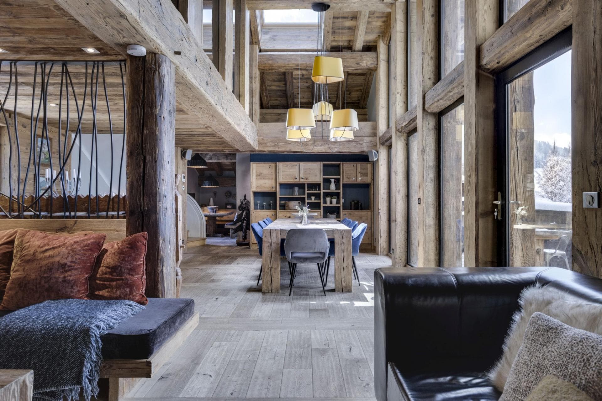 Dining area seats 10; double-height timber ceilings and snowy mountain views