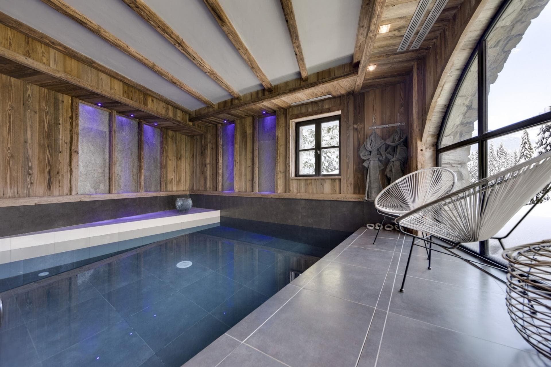 Indoor pool with integrated mood lighting and snowy forest views