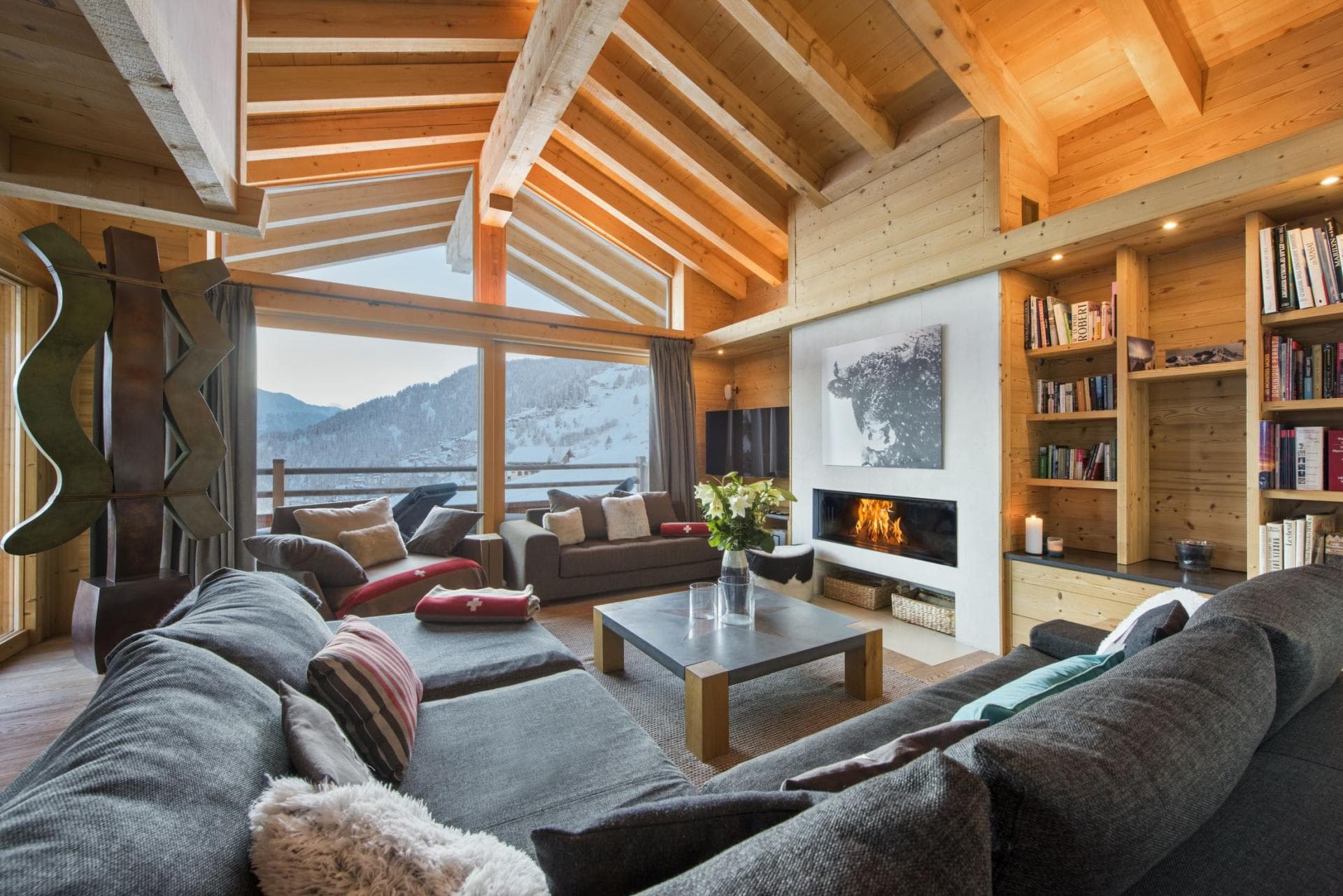 Living area with wood-burning fireplace and floor-to-ceiling mountain views
