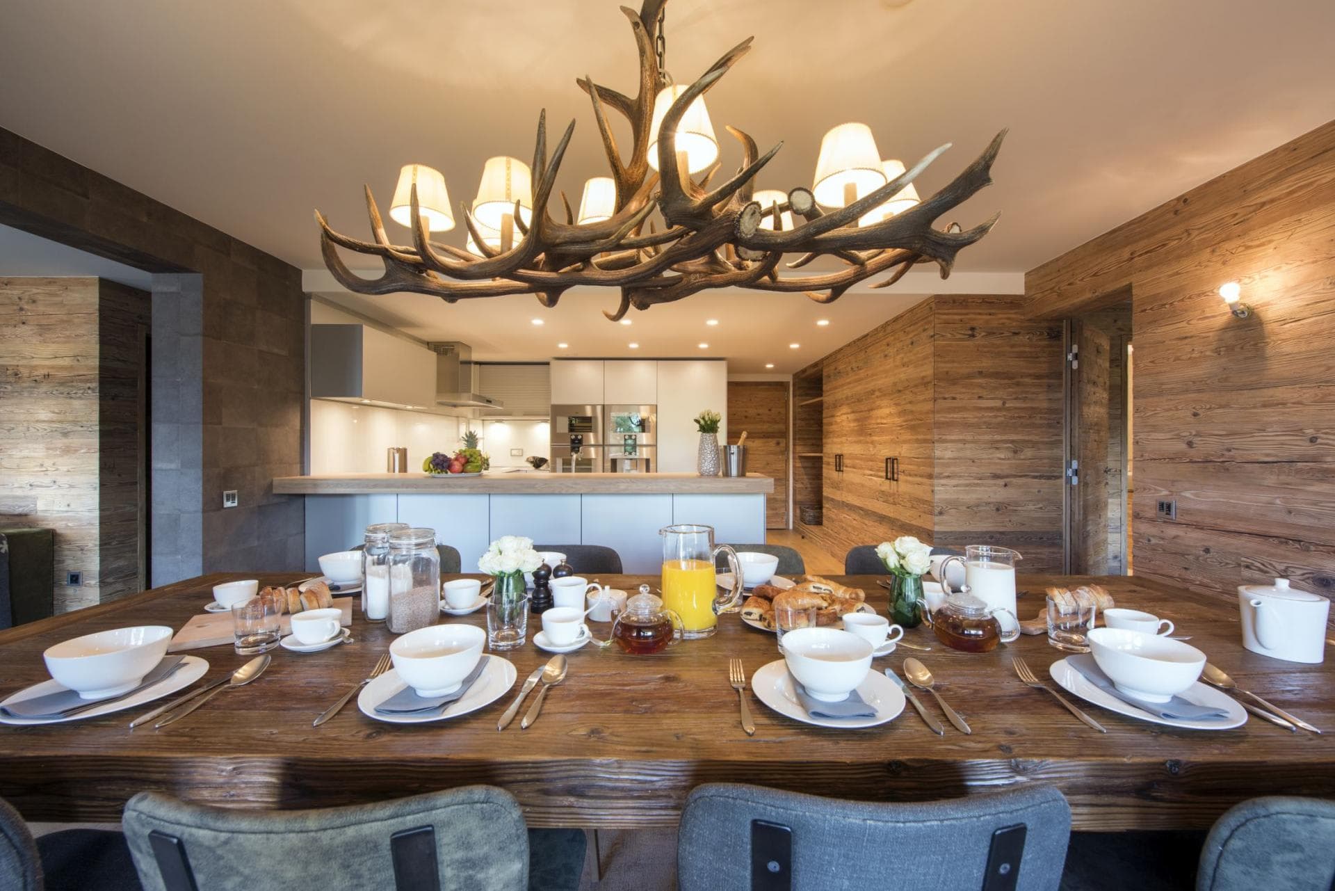 Dining area with antler chandelier; kitchen with built-in espresso machine
