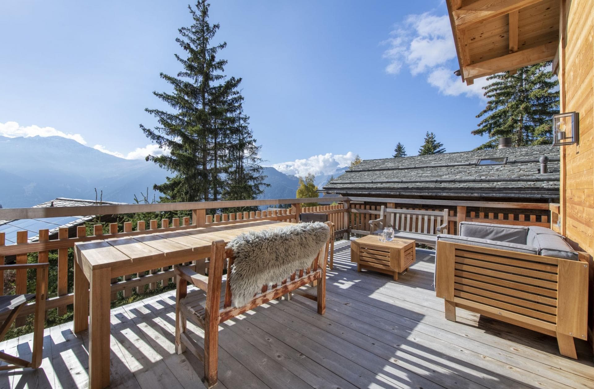 Wooden sun deck with dining table and mountain valley views