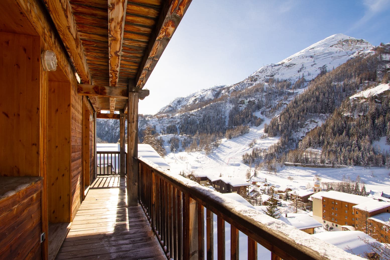 Covered wooden balcony with views of ski runs and alpine village