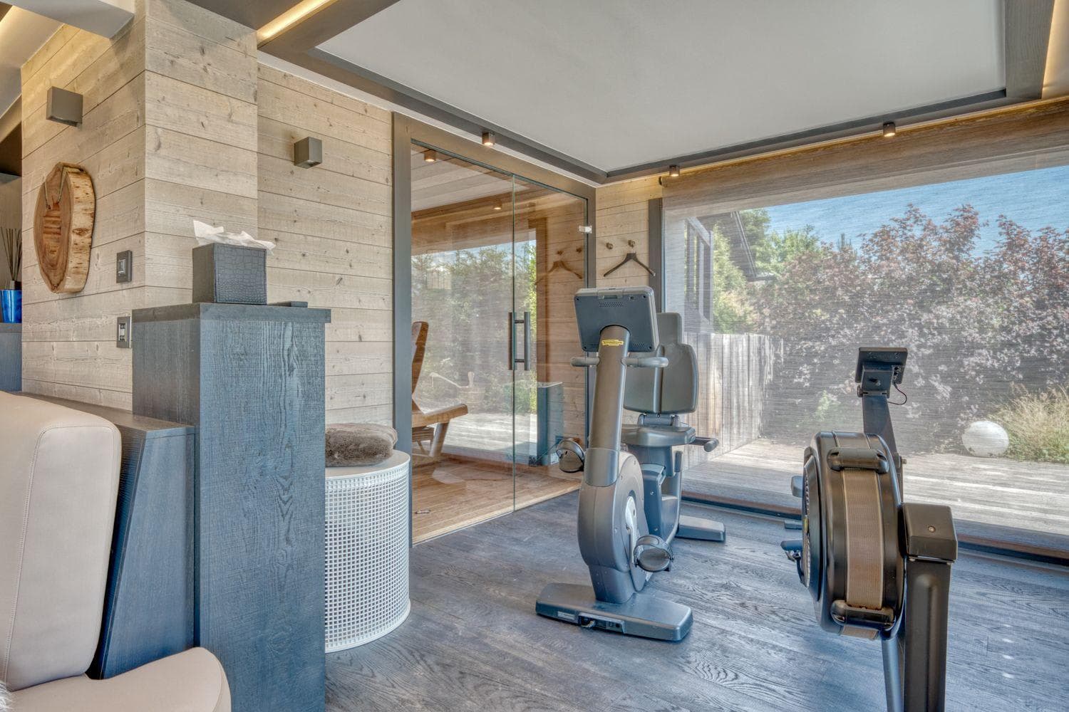 Fitness room with Technogym equipment and glass-enclosed sauna