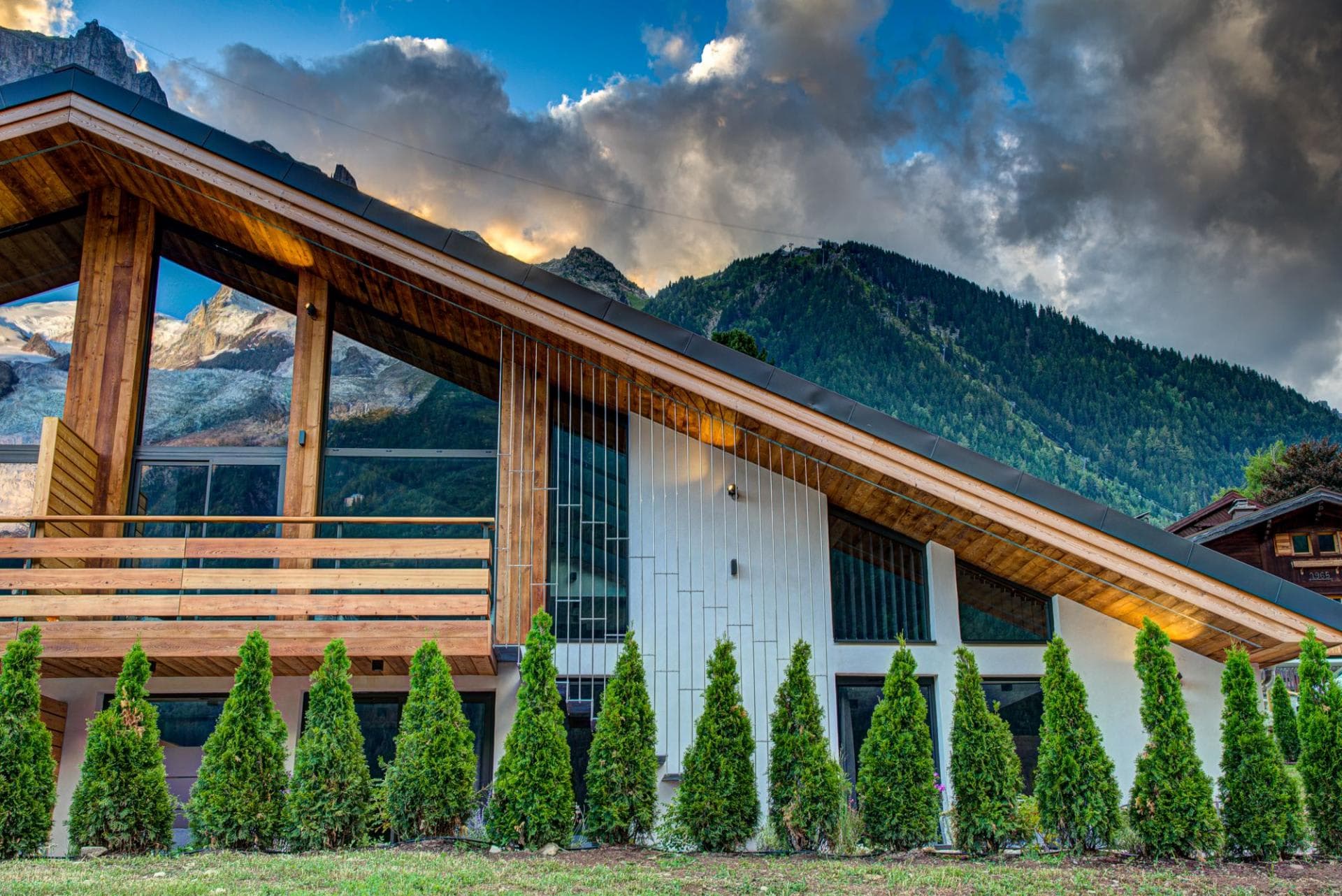 Chalet exterior with mountain-facing balcony and floor-to-ceiling windows