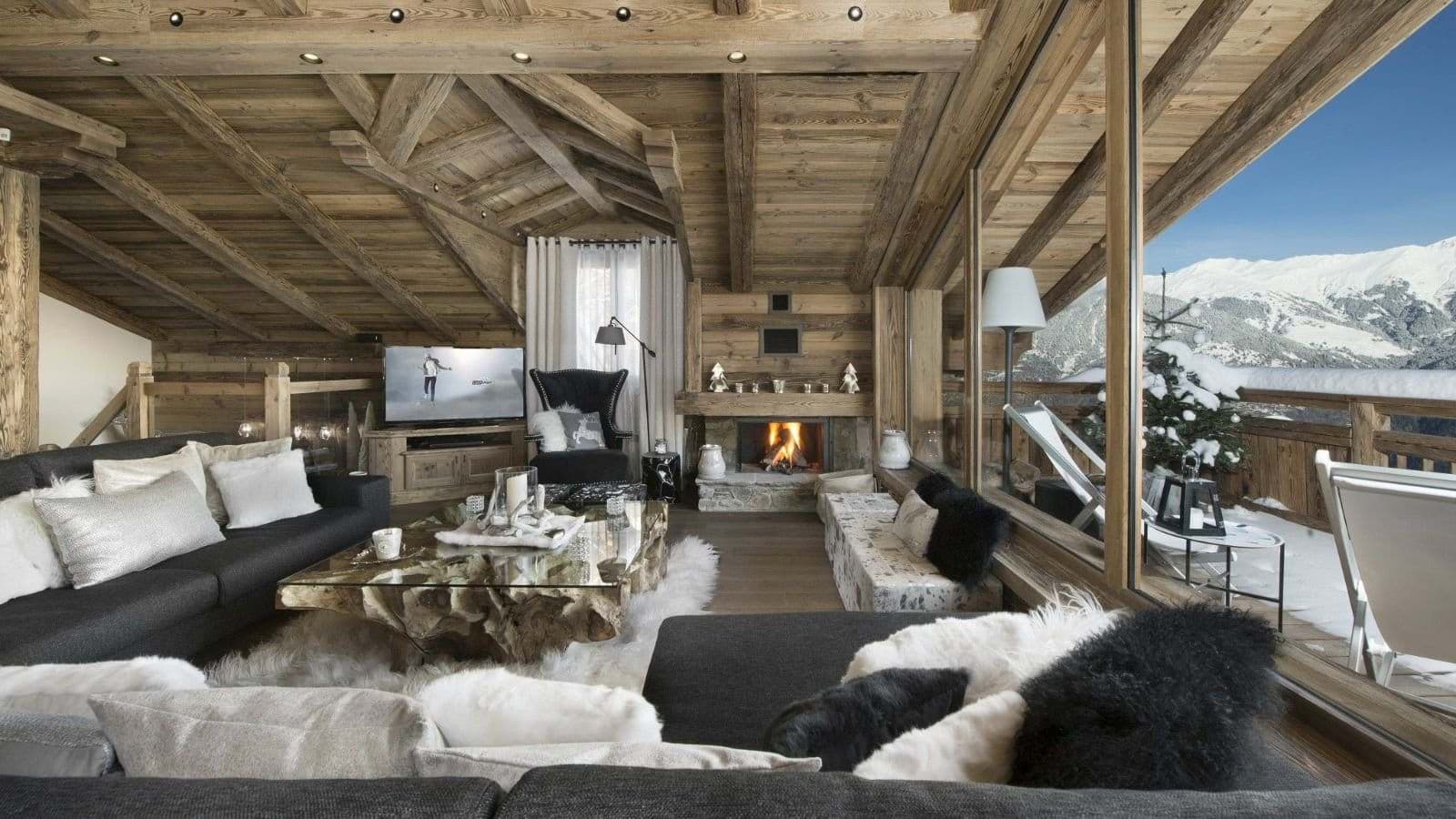 Living area with wood-burning fireplace and floor-to-ceiling mountain views