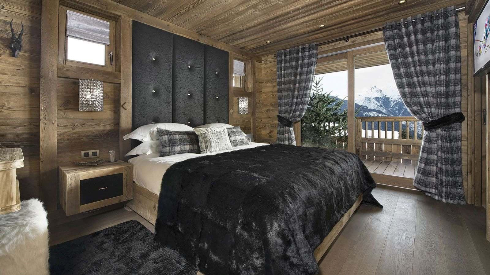 Primary bedroom with king bed and private balcony mountain views