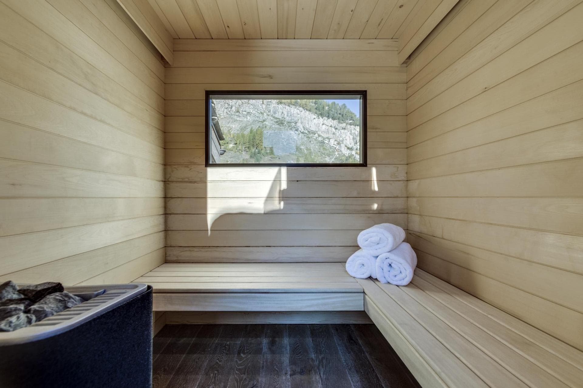 Private sauna with bench seating and mountain cliff views