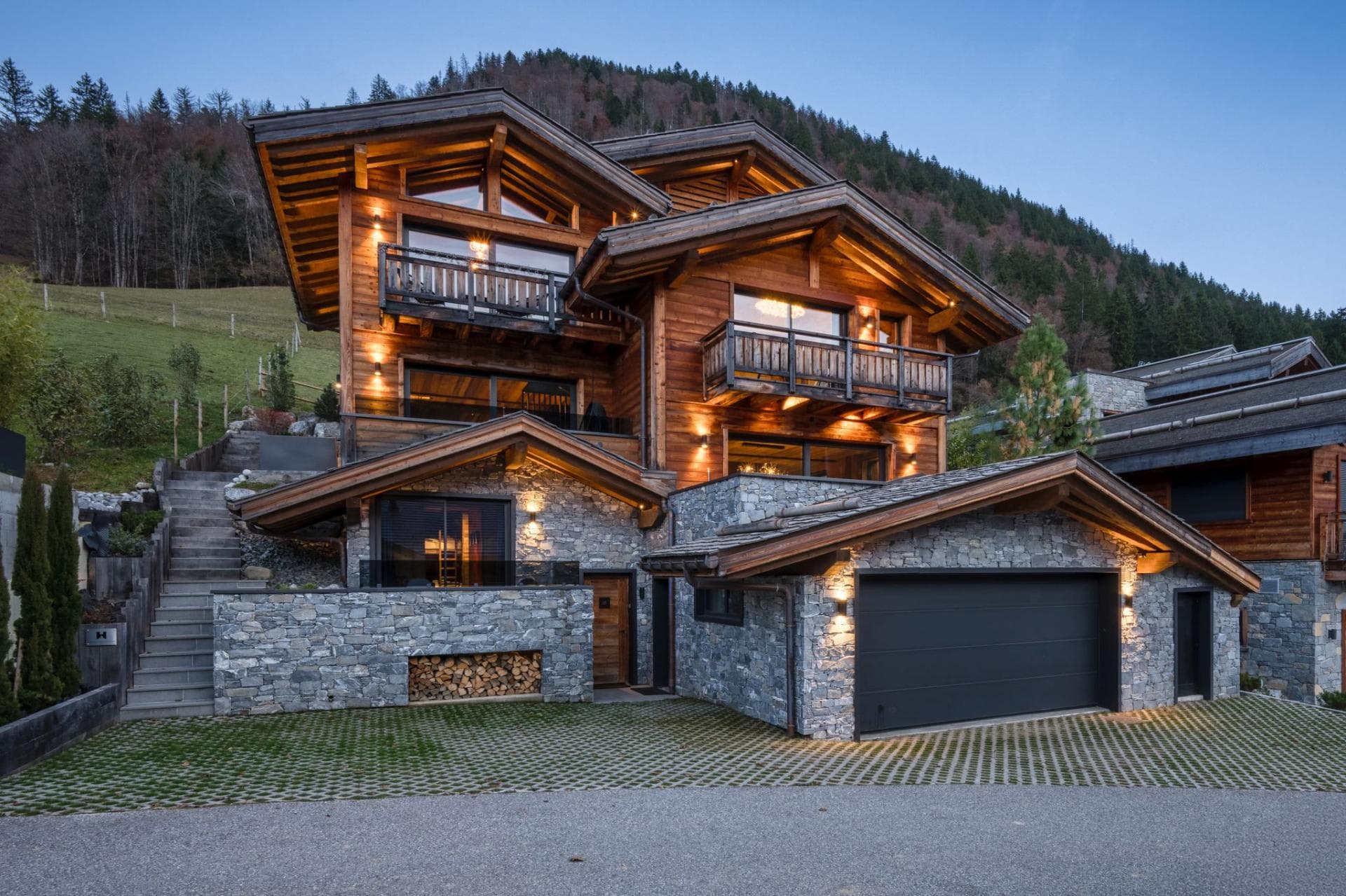 Chalet exterior with two-car garage, private balconies, and stone masonry