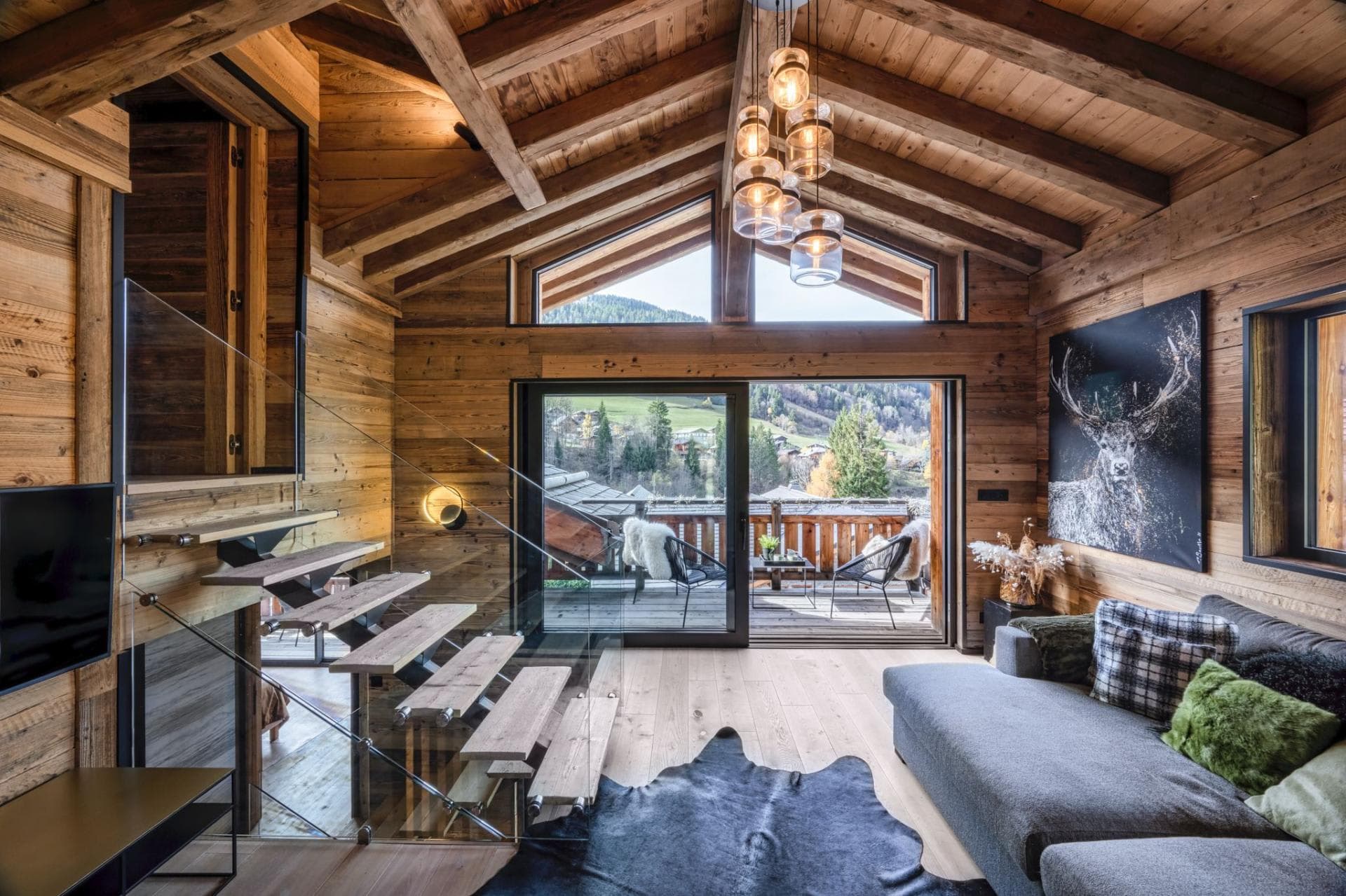 Living area with vaulted ceilings and balcony access to valley views
