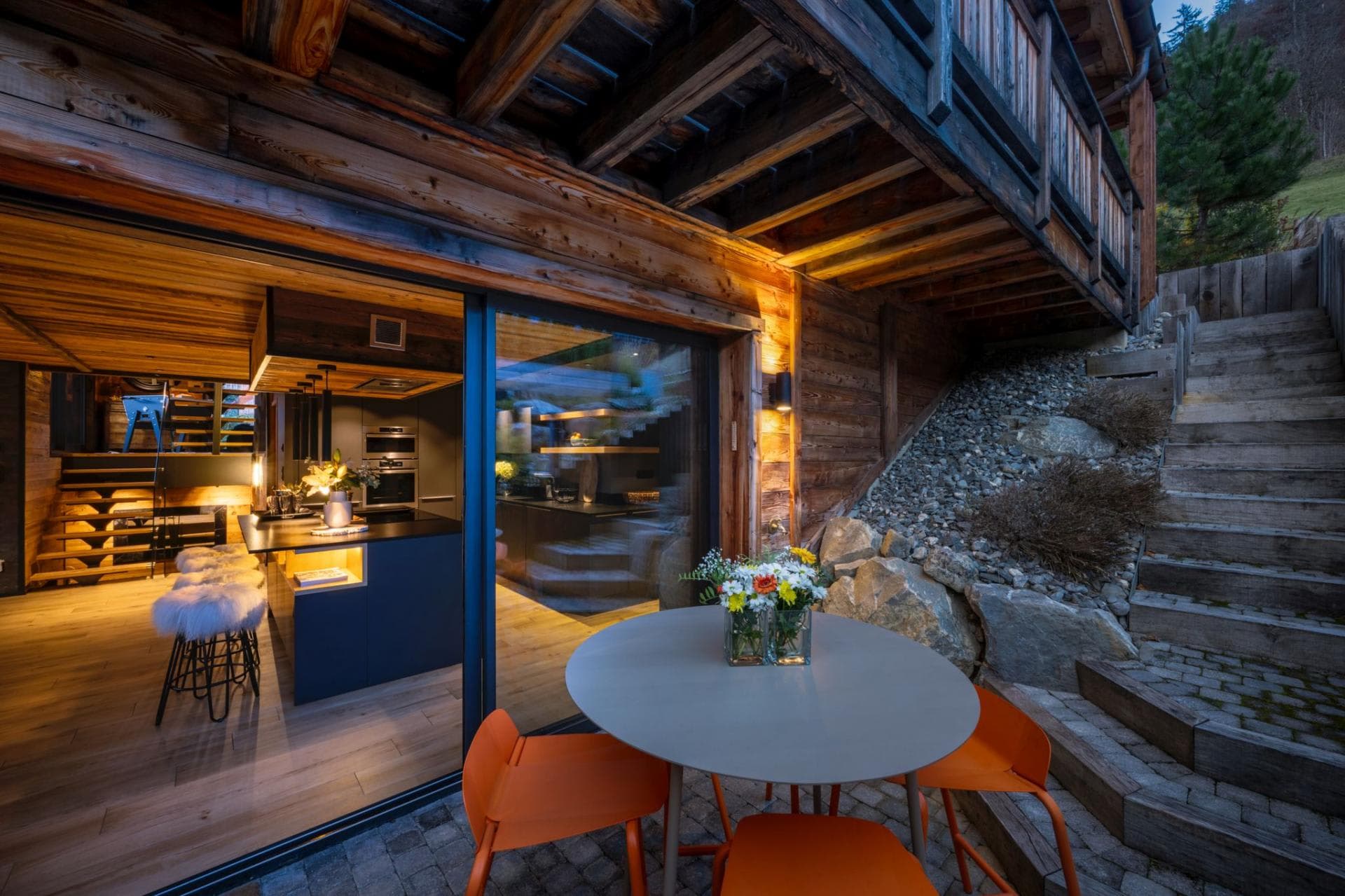 Lower-level stone patio with dining table and direct kitchen access