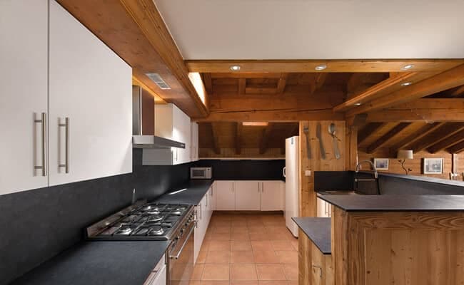 Kitchen with 5-burner gas range and exposed timber beams