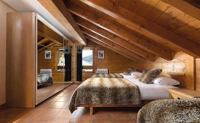 Attic bedroom with two twin beds and mirrored wardrobe