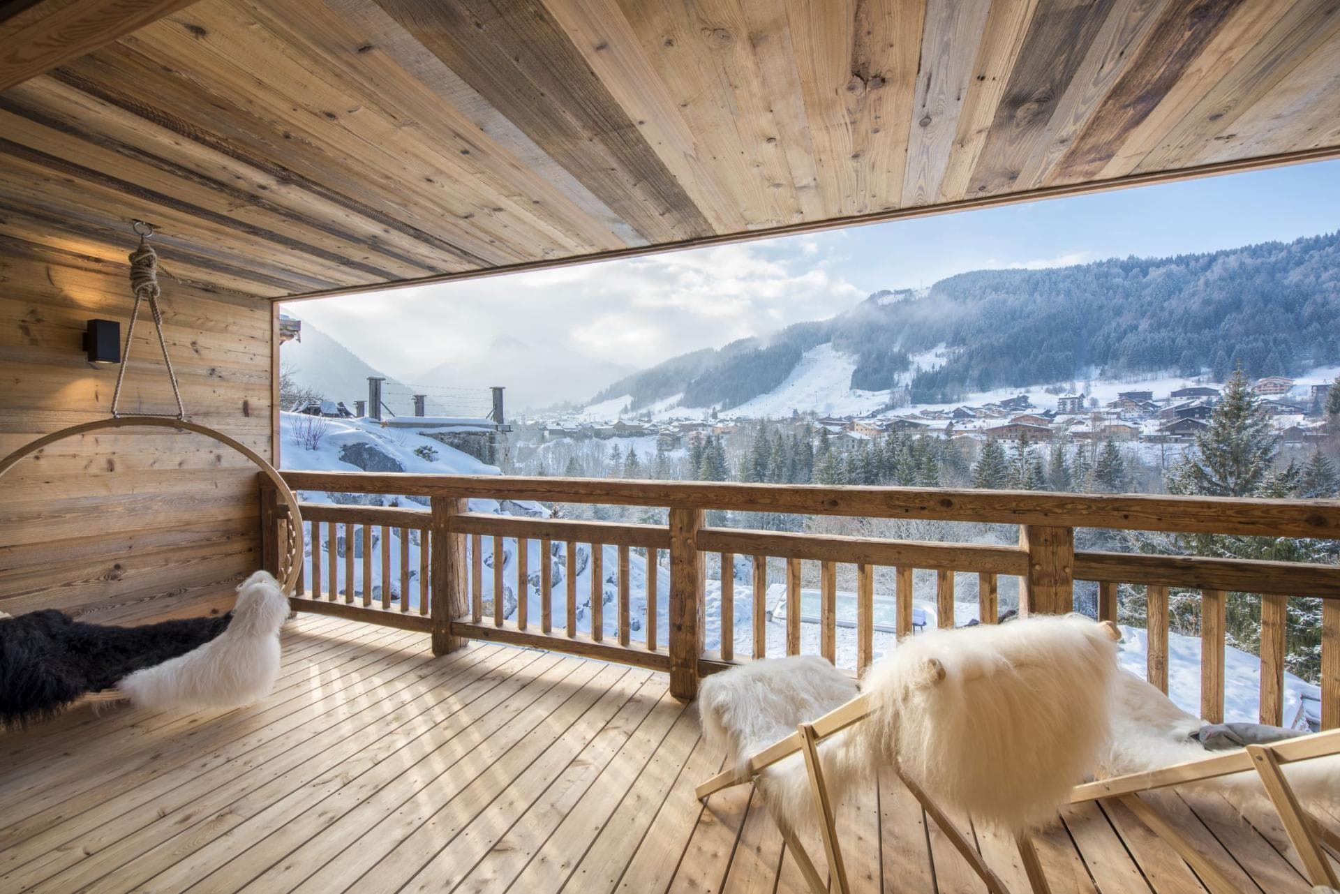 Covered wood balcony with hanging swing and valley views