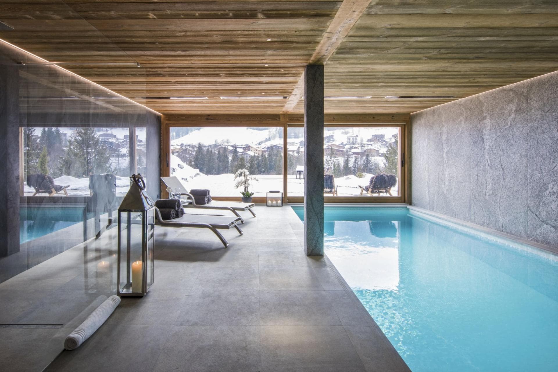 Indoor pool area with mountain views and poolside lounge seating