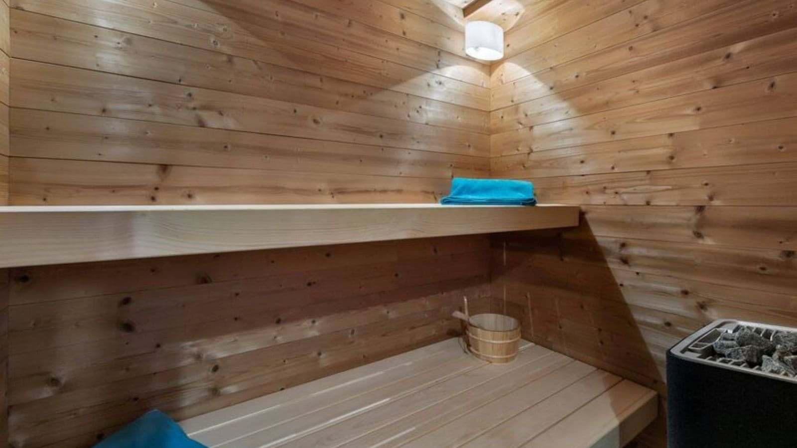 Cedar-lined sauna with electric heater and two-tier bench seating