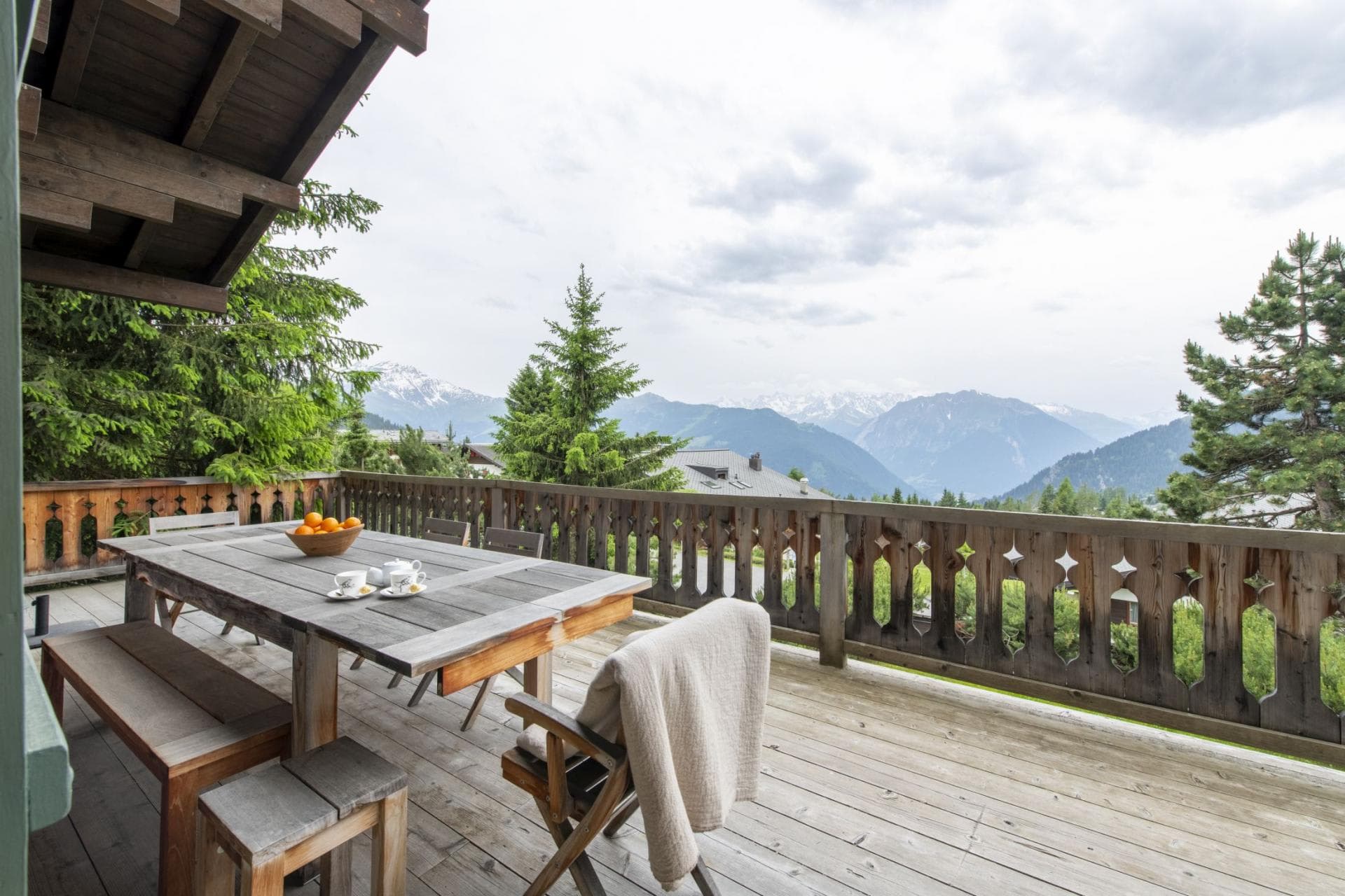 Wooden terrace with dining table and panoramic mountain views