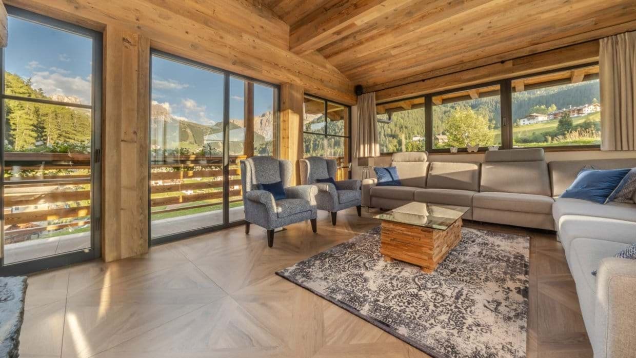 Living area with parquet flooring, sectional seating, and balcony access