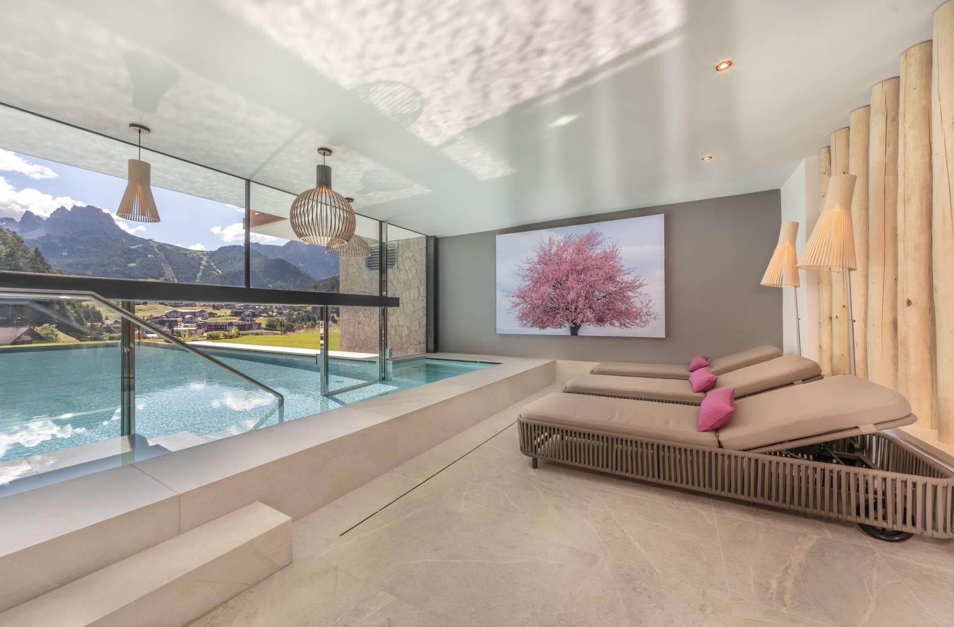 Indoor-outdoor infinity pool with mountain views and padded lounge seating