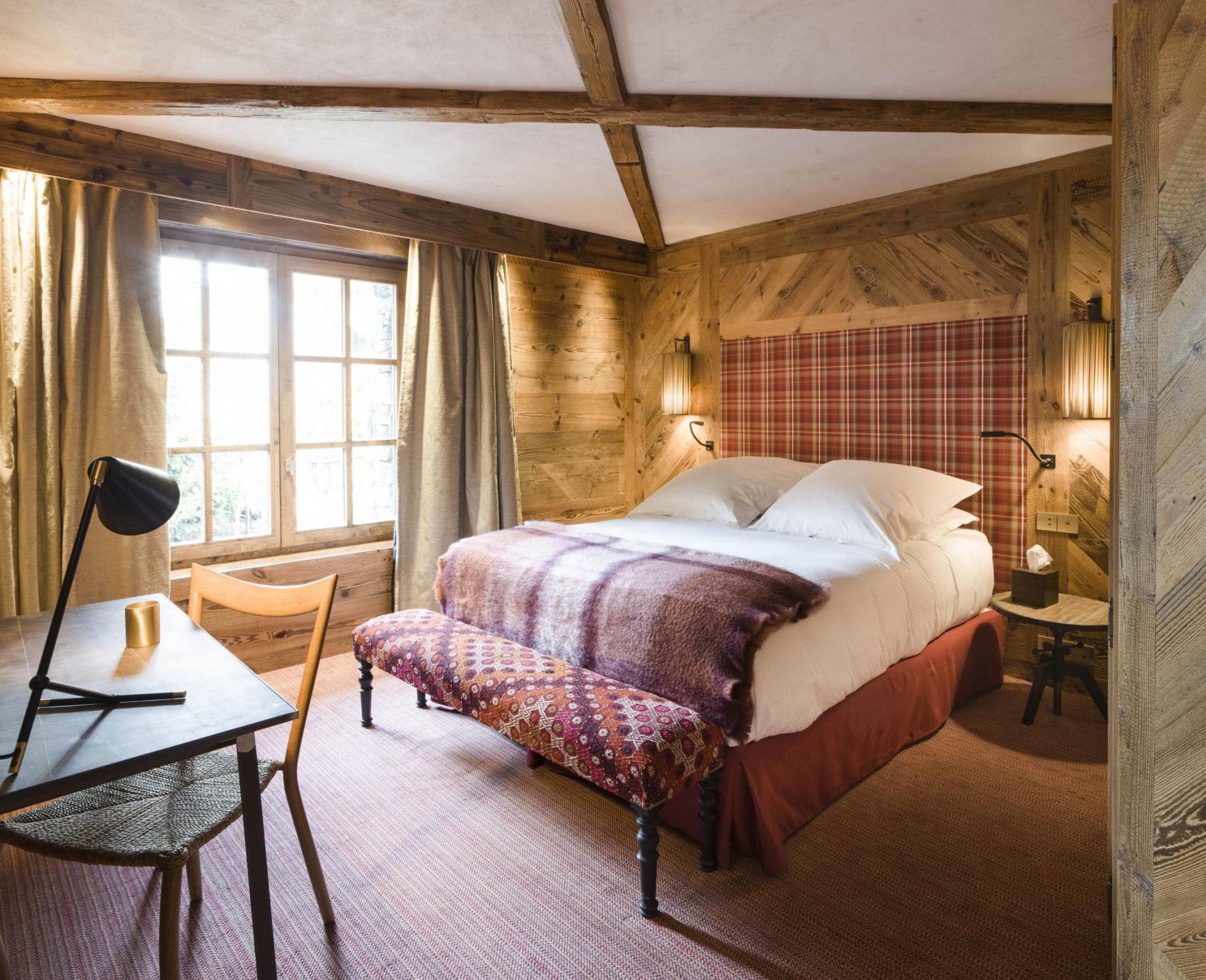 Guest bedroom with queen bed, dedicated workspace, and reclaimed wood paneling