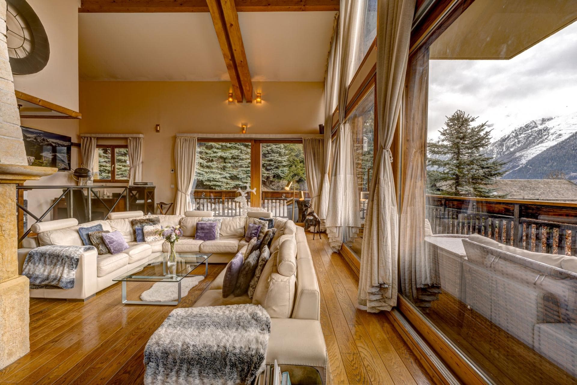 Living area with wrap-around sectional seating and floor-to-ceiling mountain views
