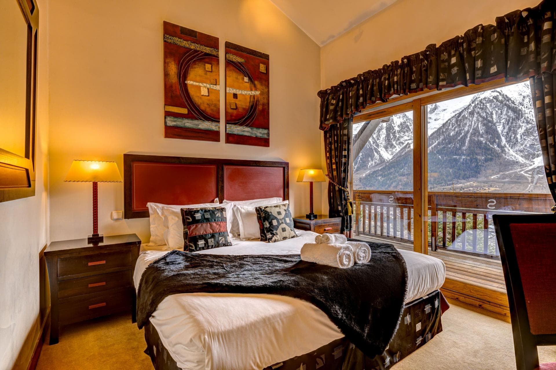Primary bedroom with queen bed and private balcony mountain views