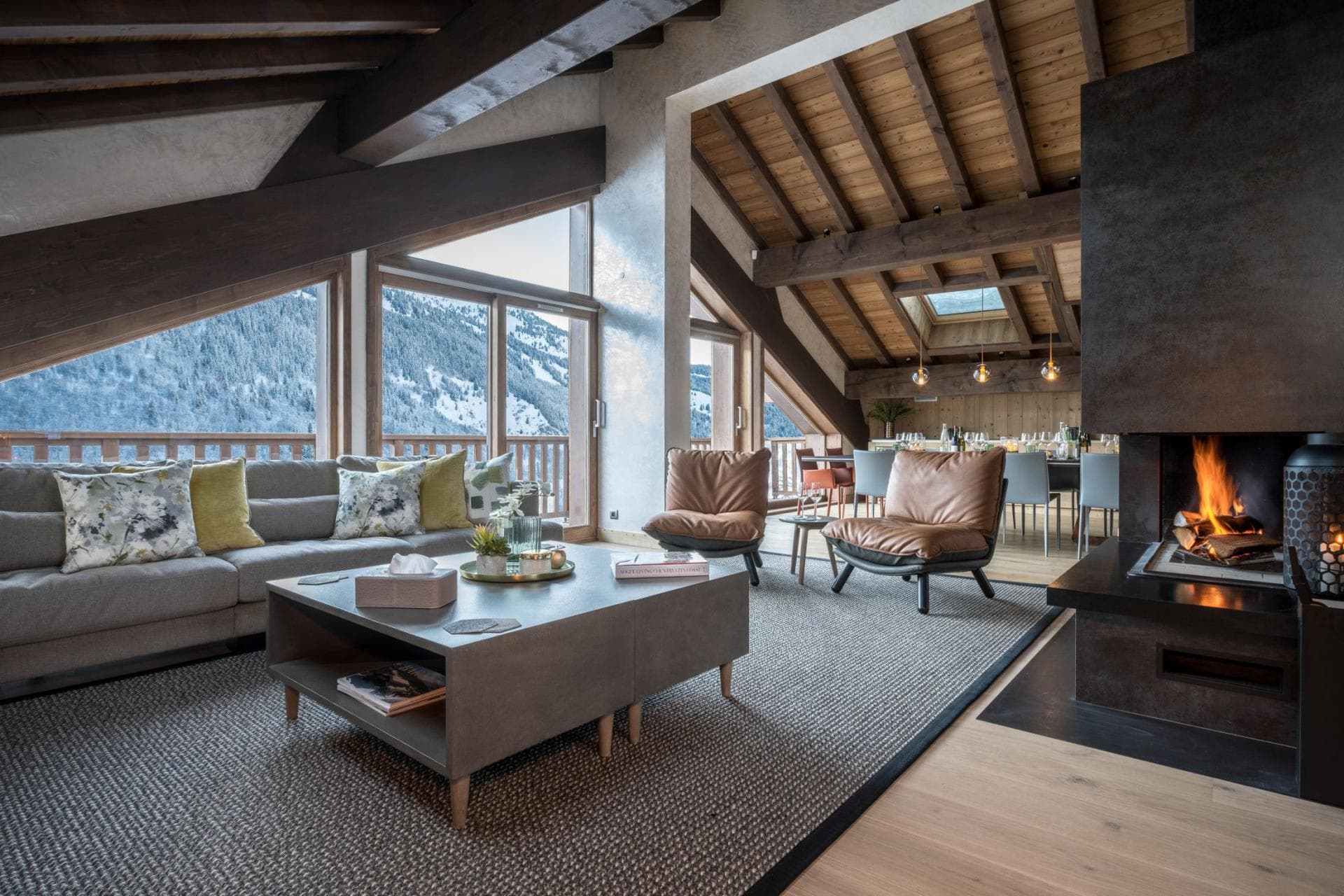 Living area with wood-burning fireplace and mountain-view balcony access