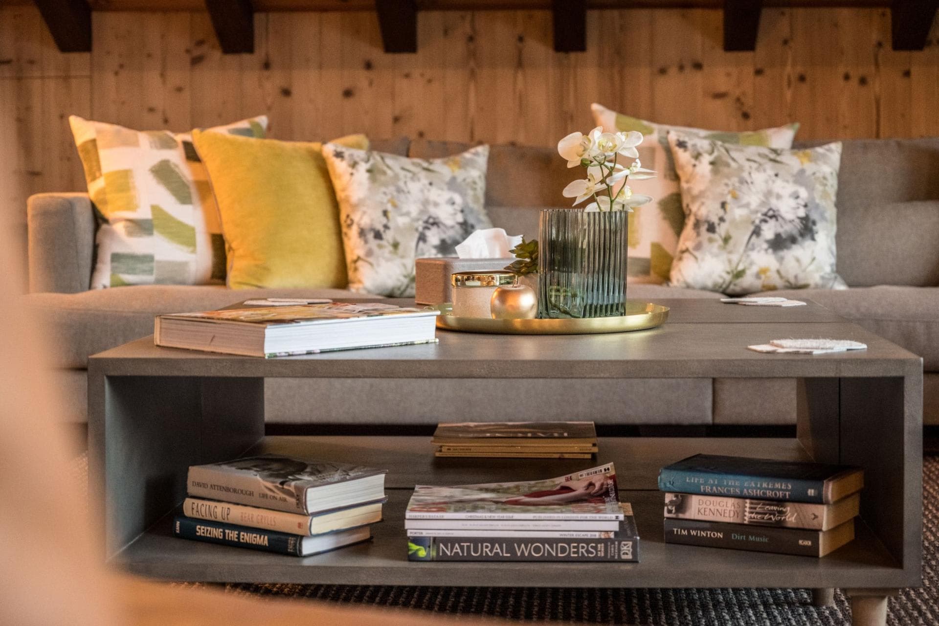 Living area coffee table with integrated book storage and wood-paneled walls