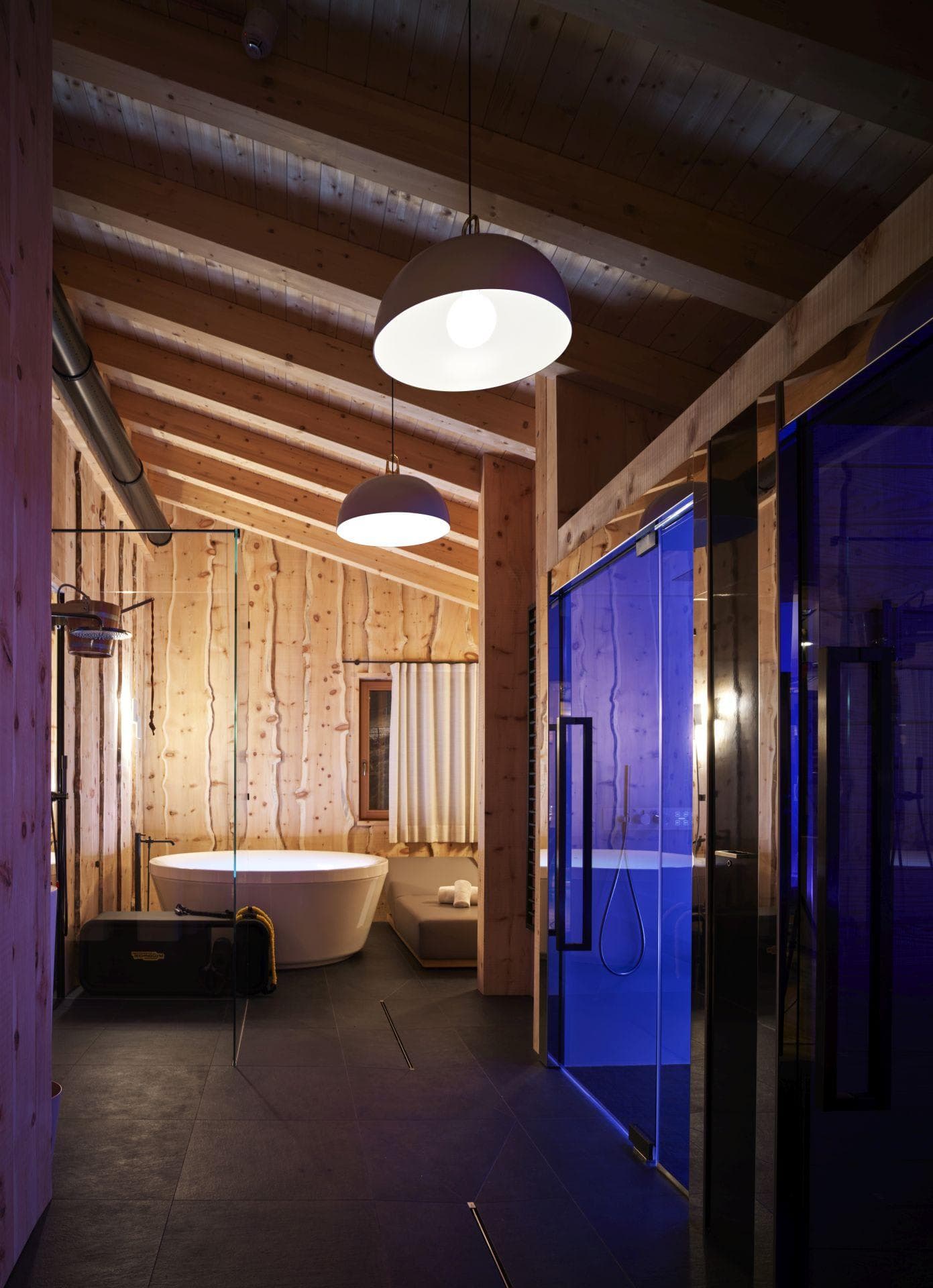 Spa bathroom with circular soaking tub and private glass-enclosed sauna