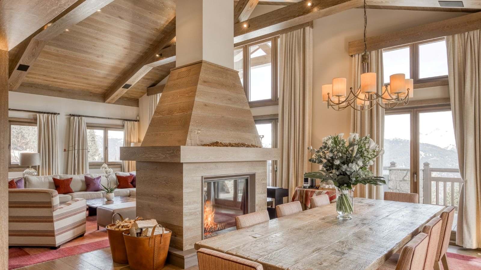 Open-plan dining and living area with double-sided fireplace and mountain views