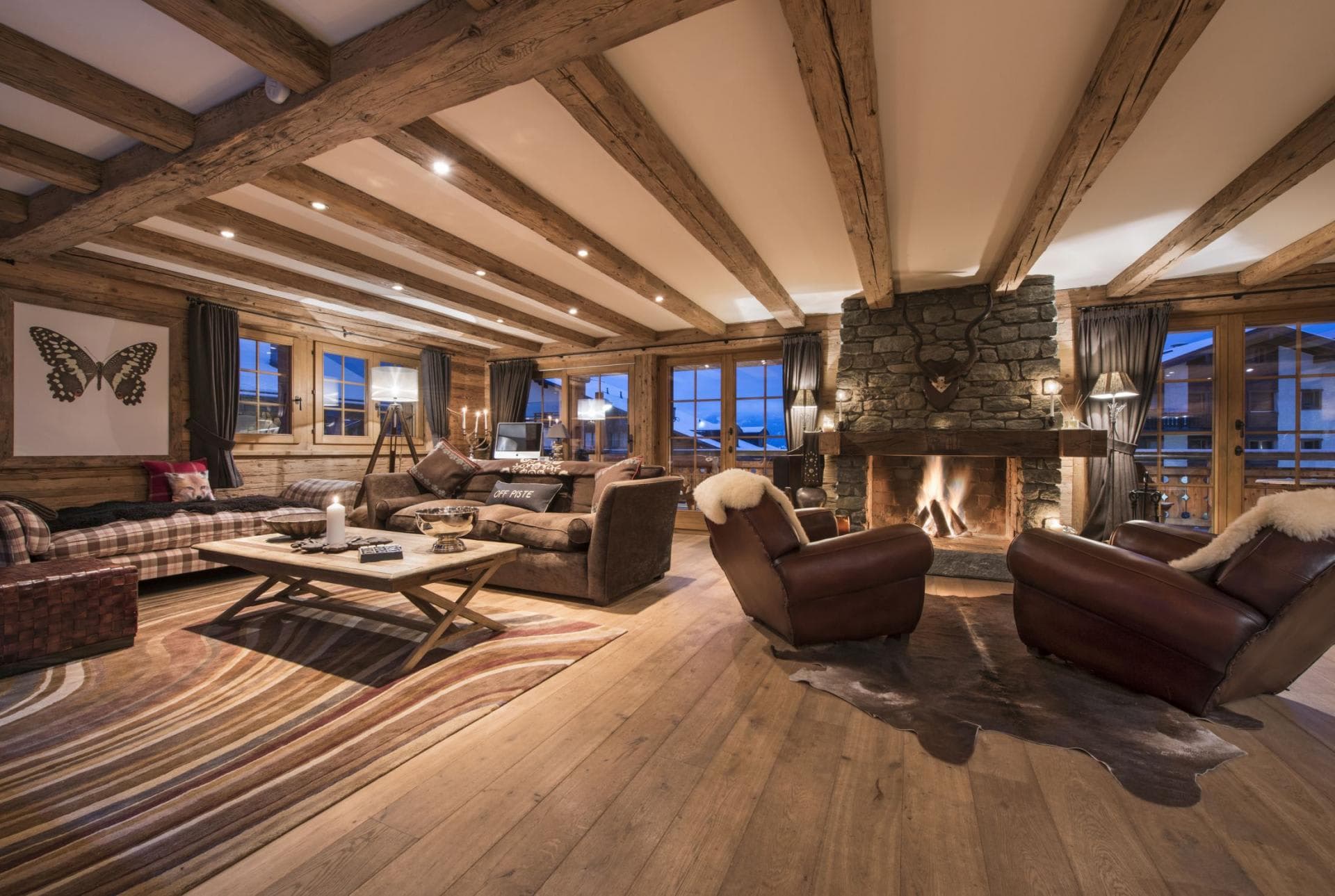 Living area with wood-burning stone fireplace and reclaimed timber ceilings